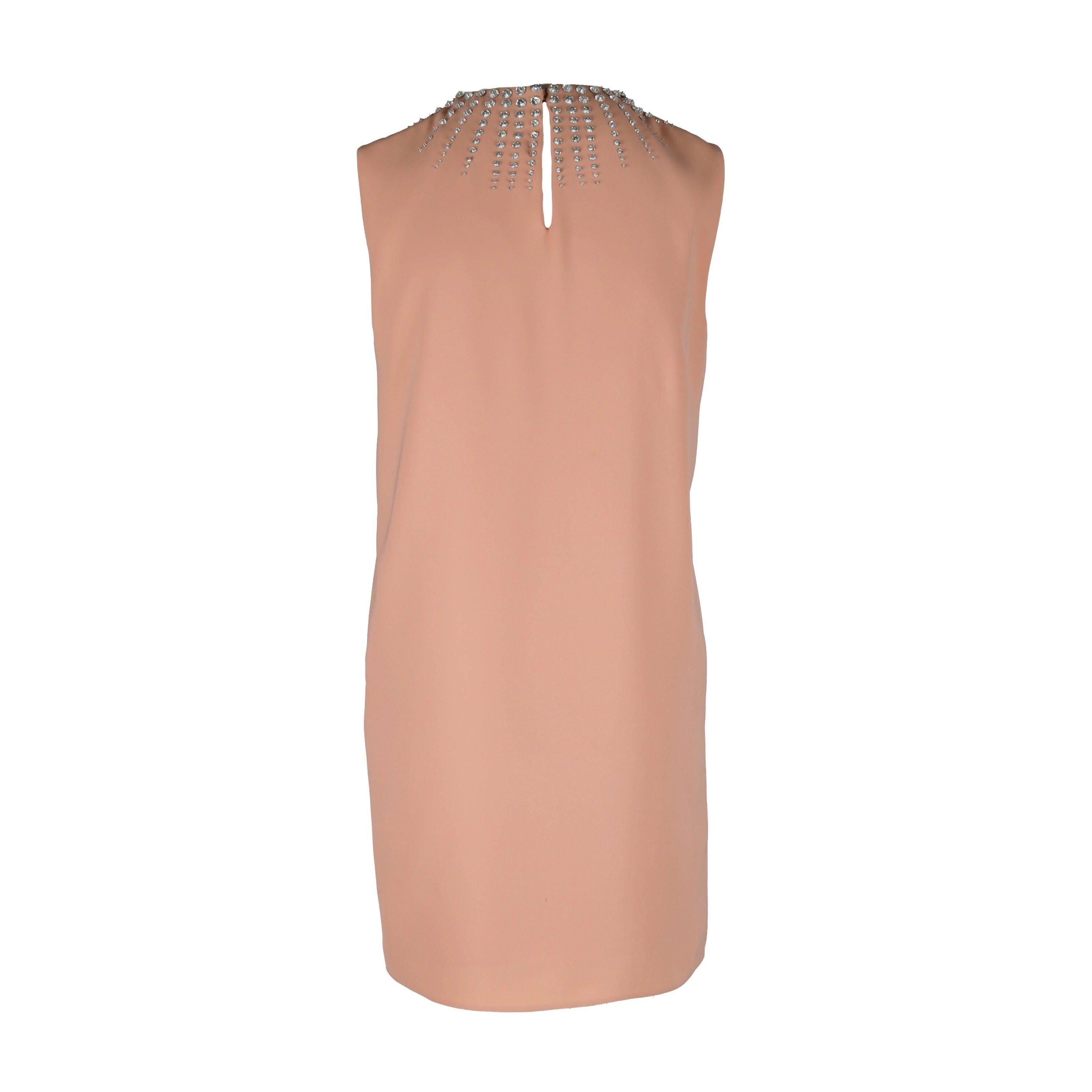 This Miu Miu short dress offers a stylish addition to any wardrobe. Crafted in a luxurious peach hue, it features a sleeveless shift silhouette, a round collar, and a cascade of stone embellishment along its neckline for a hint of sparkle. A