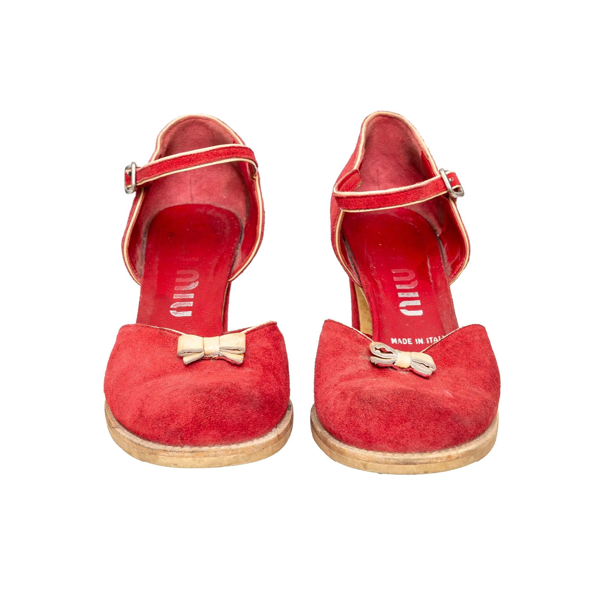 Vintage Miu Miu pumps in rich red suede with ankle buckle closure, high block heels, and a delicate bow detail on the upper for a feminine finish.
 Remarks: there are many signs of wear. 
 Material: Suede 
 Measurements: Insole Length:24.5;Heel:8.5