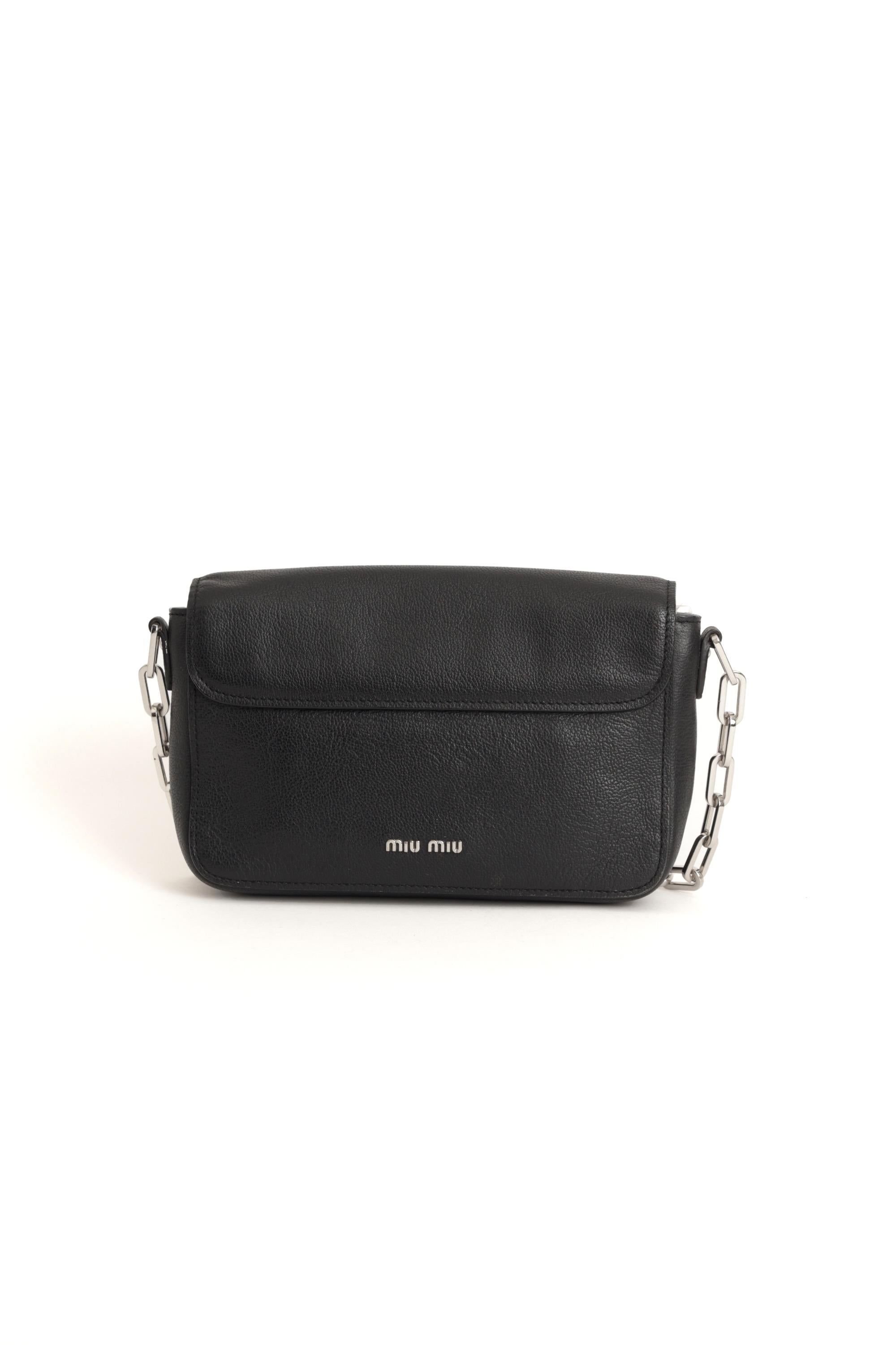 Nous sommes heureux de vous présenter ce sac transversal en cuir noir à rabat unique de Miu Miu 2000. Il est doté d'une bandoulière en chaîne argentée, de deux compartiments, d'un fermoir à poussoir et d'une poche intérieure zippée. En parfait état.