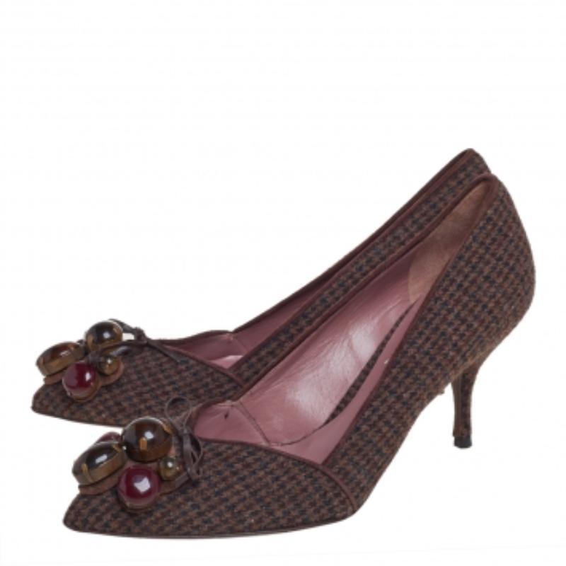 Holen Sie sich diese wunderschönen Miu Miu Pumps, um einen modischen Look zu erzielen. Die spitz zulaufenden Schuhe sind aus Wolle mit Hahnentrittmuster gefertigt und mit auffälligen Emaille-Verzierungen auf dem Obermaterial und 8 cm hohen Absätzen