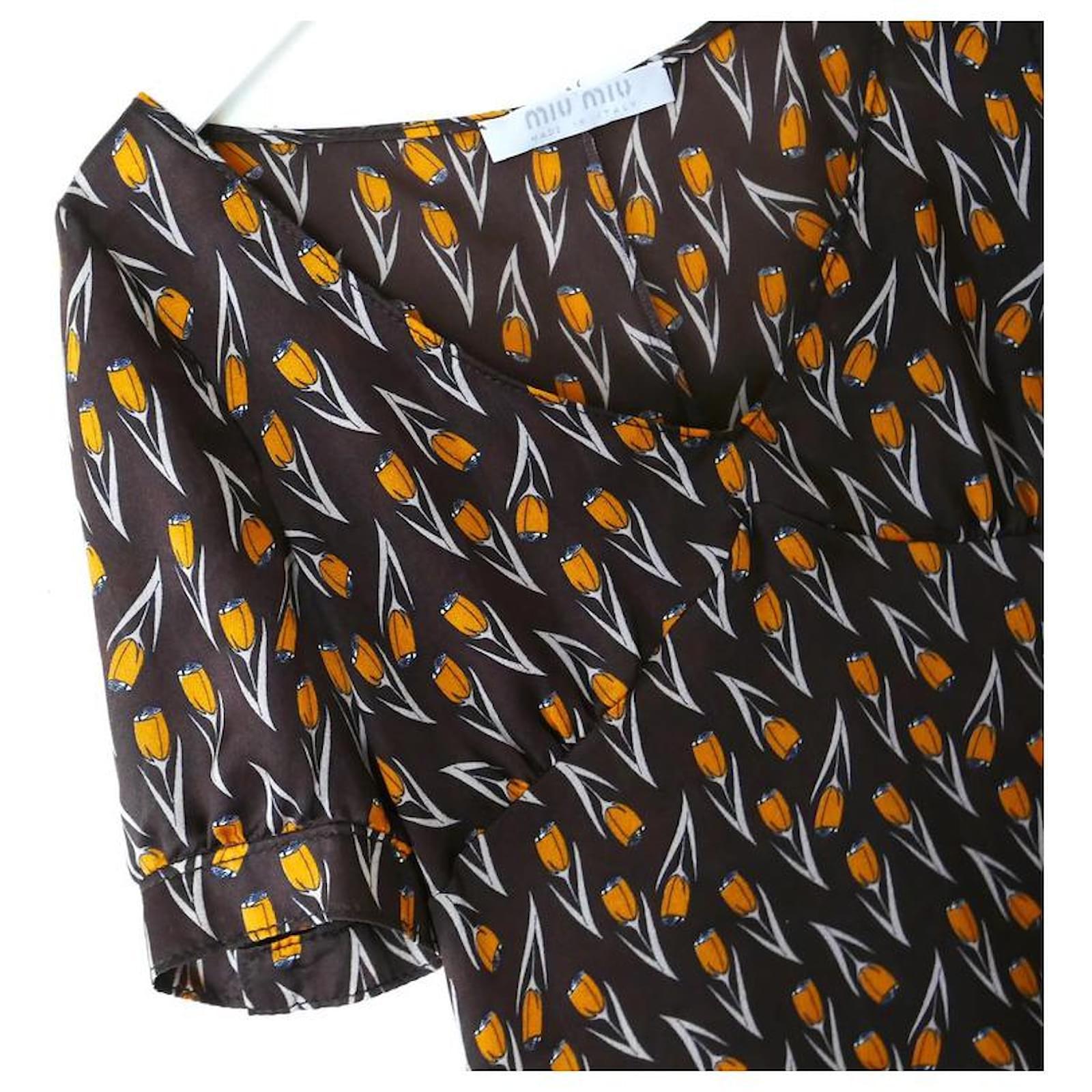 Super rare, magnifique blouse vintage Miu Miu de la Collectional Automne 2000. I superbe état vintage. Réalisé en crêpe de chine de soie marron, fin et délicat, avec un superbe imprimé floral orange. 
Il présente une coupe inspirée des années 1930,