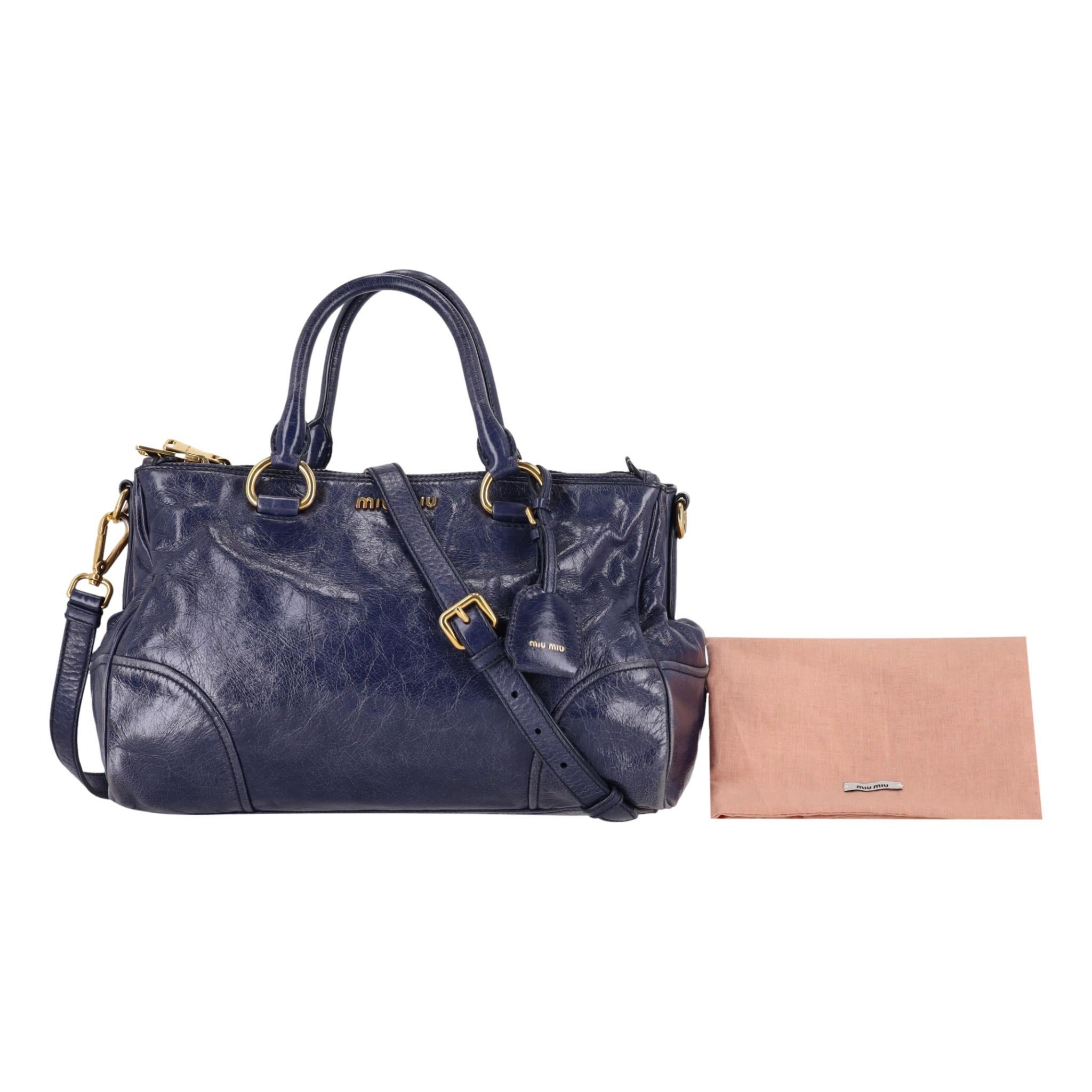 Miu Miu - Sac en cuir Vitello

Sac à main en cuir brillant de couleur marine, avec inscription dorée 