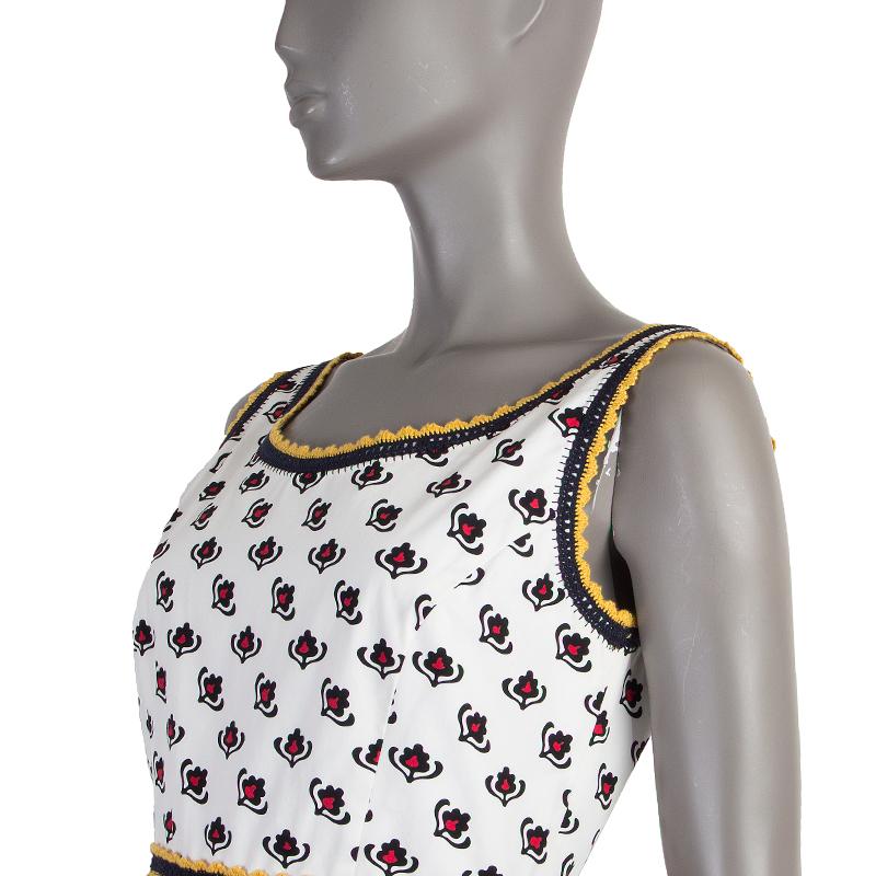 100% authentic Miu Miu pleated floral dress in white, black, midnight blue, yellow, and red cotton (100%). With lace trims. Closes with one hook and invisible zipper on the back. Lined in white cotton (100%). Has been worn and is in excellent