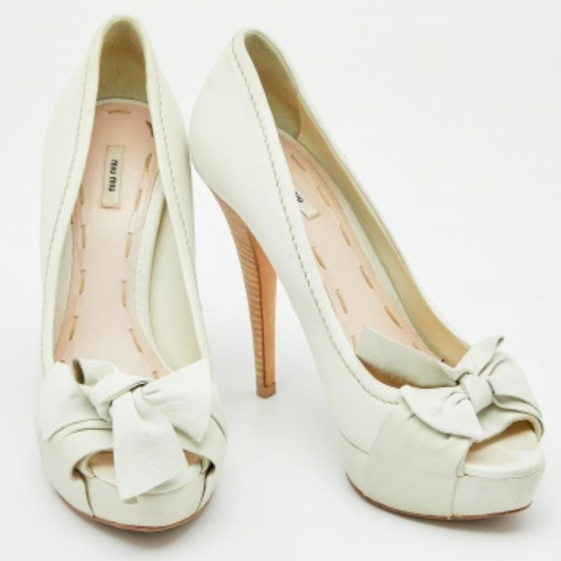 Adorned with pretty bows, Miu Miu's peep-toe pumps are a feminine twist on the classy shoe design. The white hue and distinguished heels are sure to woo the crowd with their stylish appeal. Team them with a printed dress and colorful accessories for