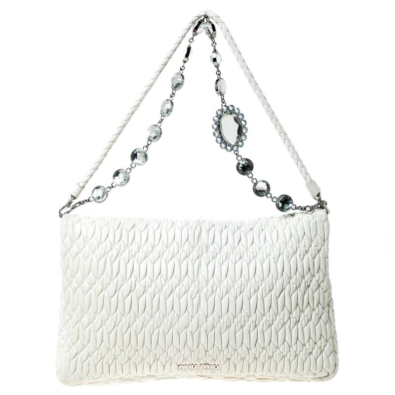 Stay up to date with fashion with this exclusive piece from Miu Miu. Crafted from white Matelasse leather, this bag features a crystal embellished chain detail to add an element of glamour. It comes with a single handle and an interior that is lined