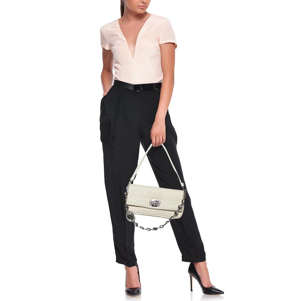 Miu Miu's pretty white bag comes made of cloquet leather. It has a leather handle and a metal shoulder strap featuring crystals. The lined interior is secured by the embellished lock on the flap.

Includes: Original Dustbag