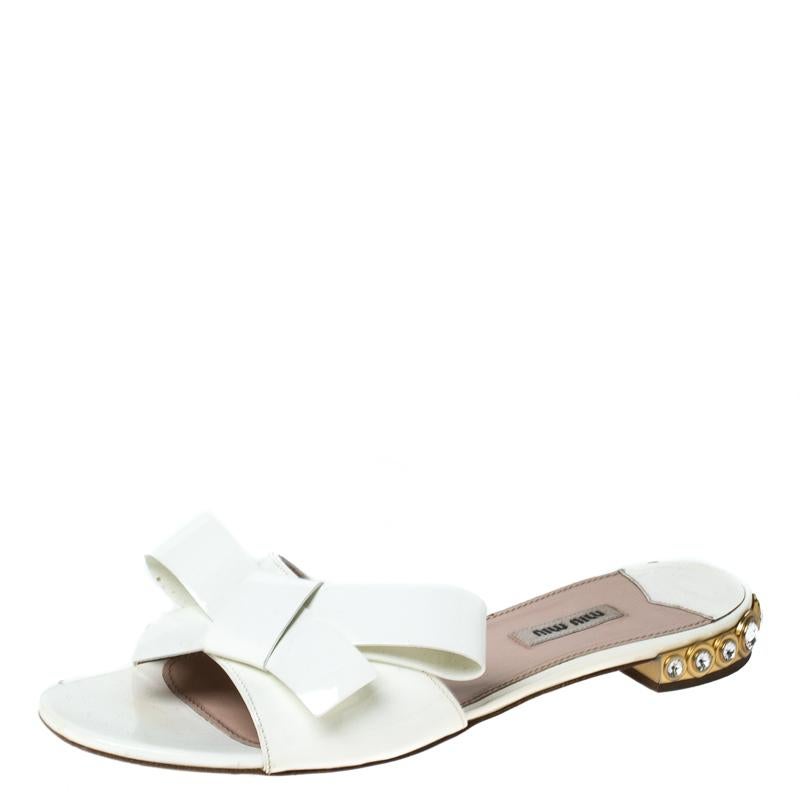 How elegant and stylish are these slides from Miu Miu! The white slides are crafted from patent leather and feature an open toe silhouette. They flaunt bow detailed vamp straps, comfortable leather-lined insoles and jewel embellished heels that make