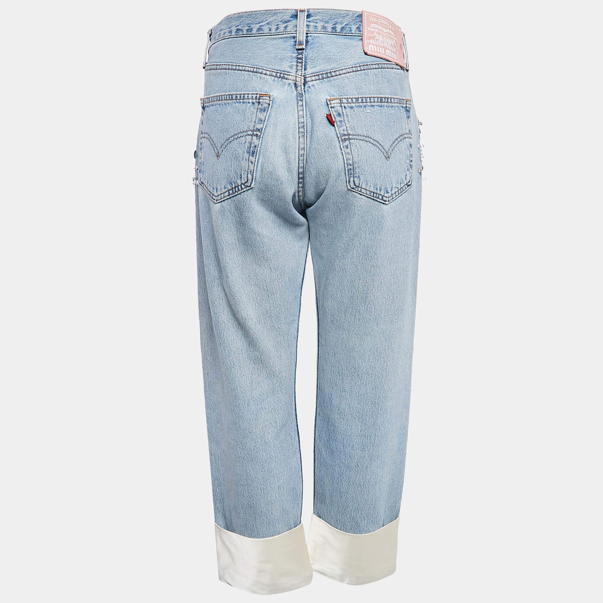 The Miu Miu x Leviâ€™s jeans bring luxury and classic denim together. These light blue jeans feature intricate crystal detailing along satin trimmed seams  blending Miu Mius high fashion elegance with Levis iconic style. Crafted for comfort and