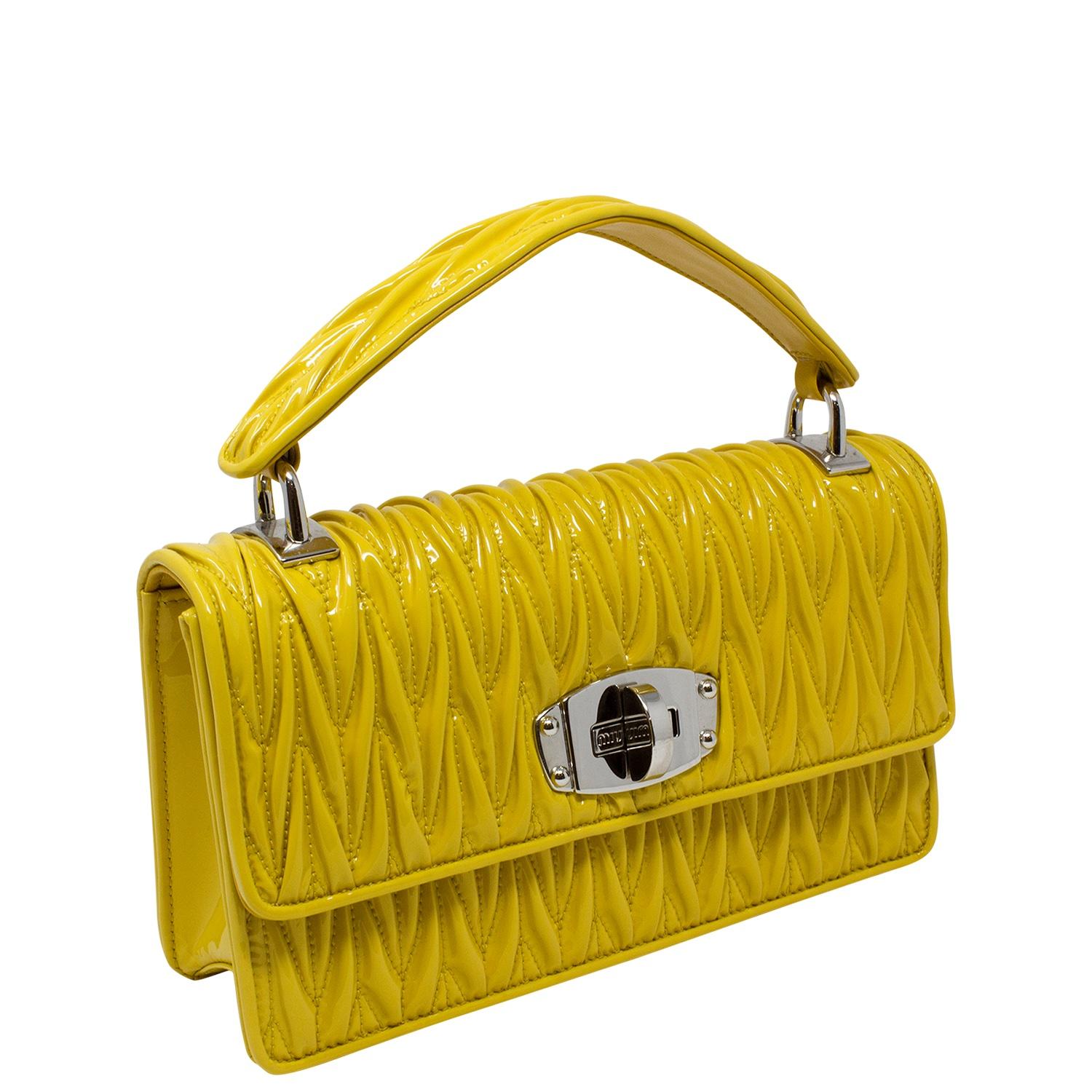 De Cru favorite! Stunning yellow chevron quilting over gorgeous patent. We love the versatility of the top handle and the removable crossbody strap. The foldover flap opens up with a twist-lock closure. The silver-tone hardware is perfect with the
