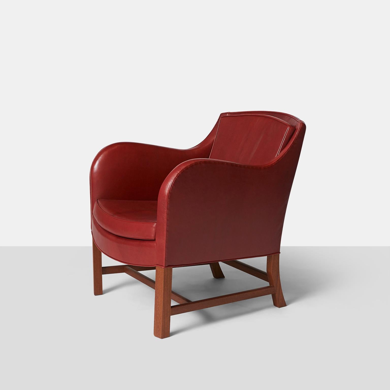 A “Mix” lounge chair by Kaare Klint made in the Rud Rasmussen factory. Upholstered in a deep cordovan leather with a mahogany frame. The top has a convex shape while the seat is concave. One of the last chairs made in the original factory with most