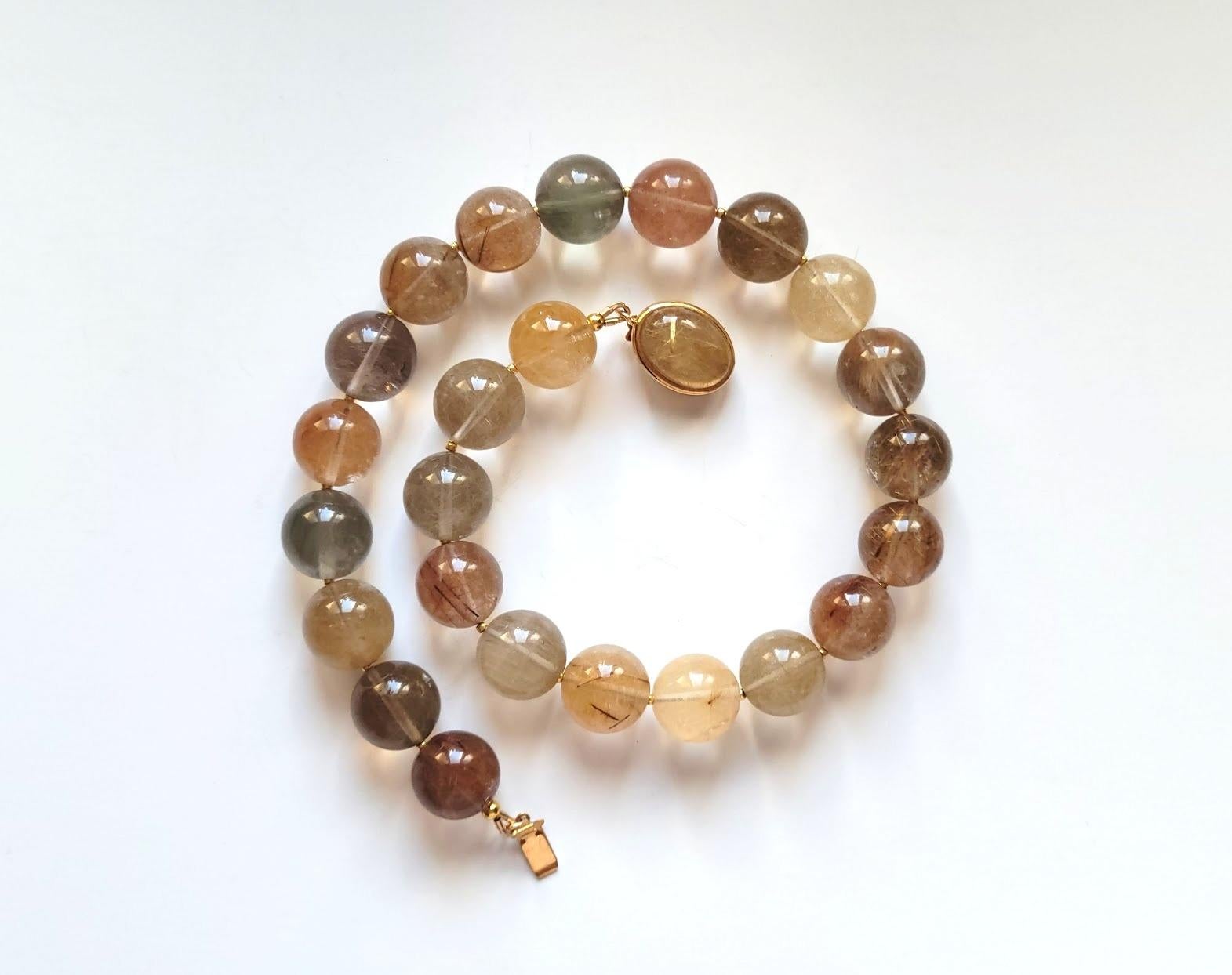 We are excited to present our newest addition to the collection - a stunning Rutilated Quartz necklace. Measuring 17.5 inches (44.5 cm) in length, this necklace is made of smooth round beads (16.5mm) in a rich reddish-brown, caramel, gold, and silky