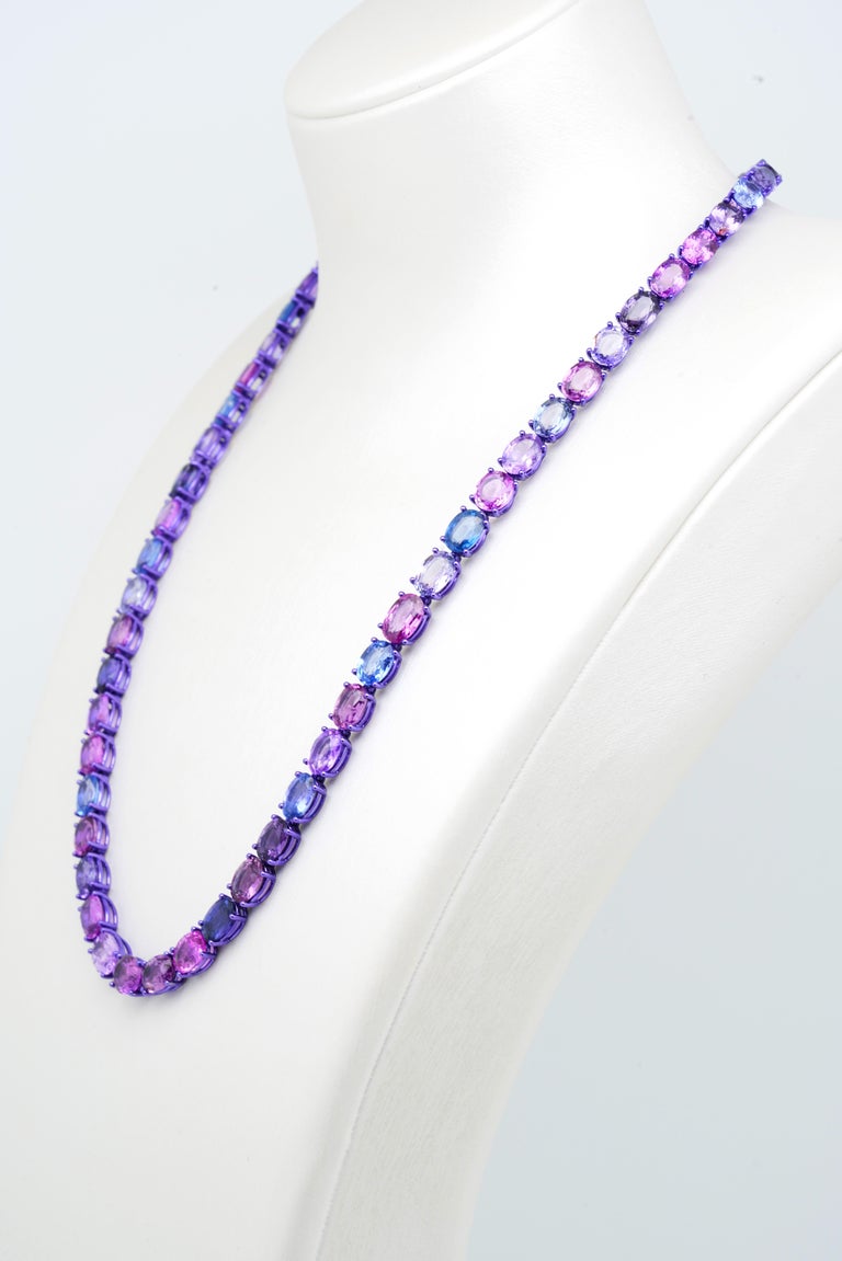 This classic yet fashion-forward Eternity Necklace in purple-colored plated 18K White Gold features a delicate row of mixed-color Sapphires, pink, blue, purple, you name it. This simply exquisite design is a timeless piece from the Psychedelic Light