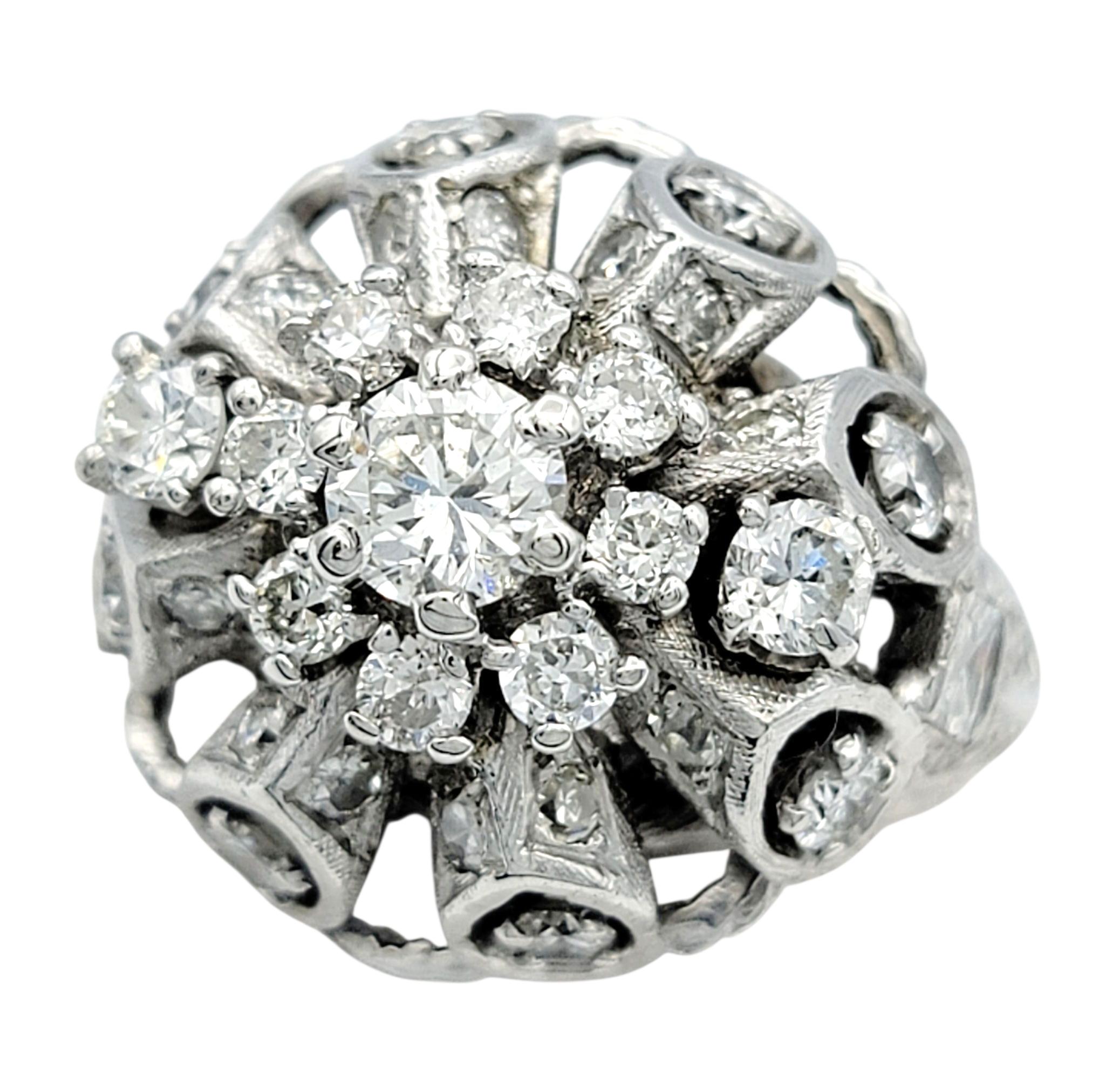 Cette éblouissante bague en diamant est conçue avec une grappe captivante de diamants ronds, simples et rectangulaires, créant une surface de brillance qui étincelle sous tous les angles. Le mélange des coupes ajoute de la texture et de la