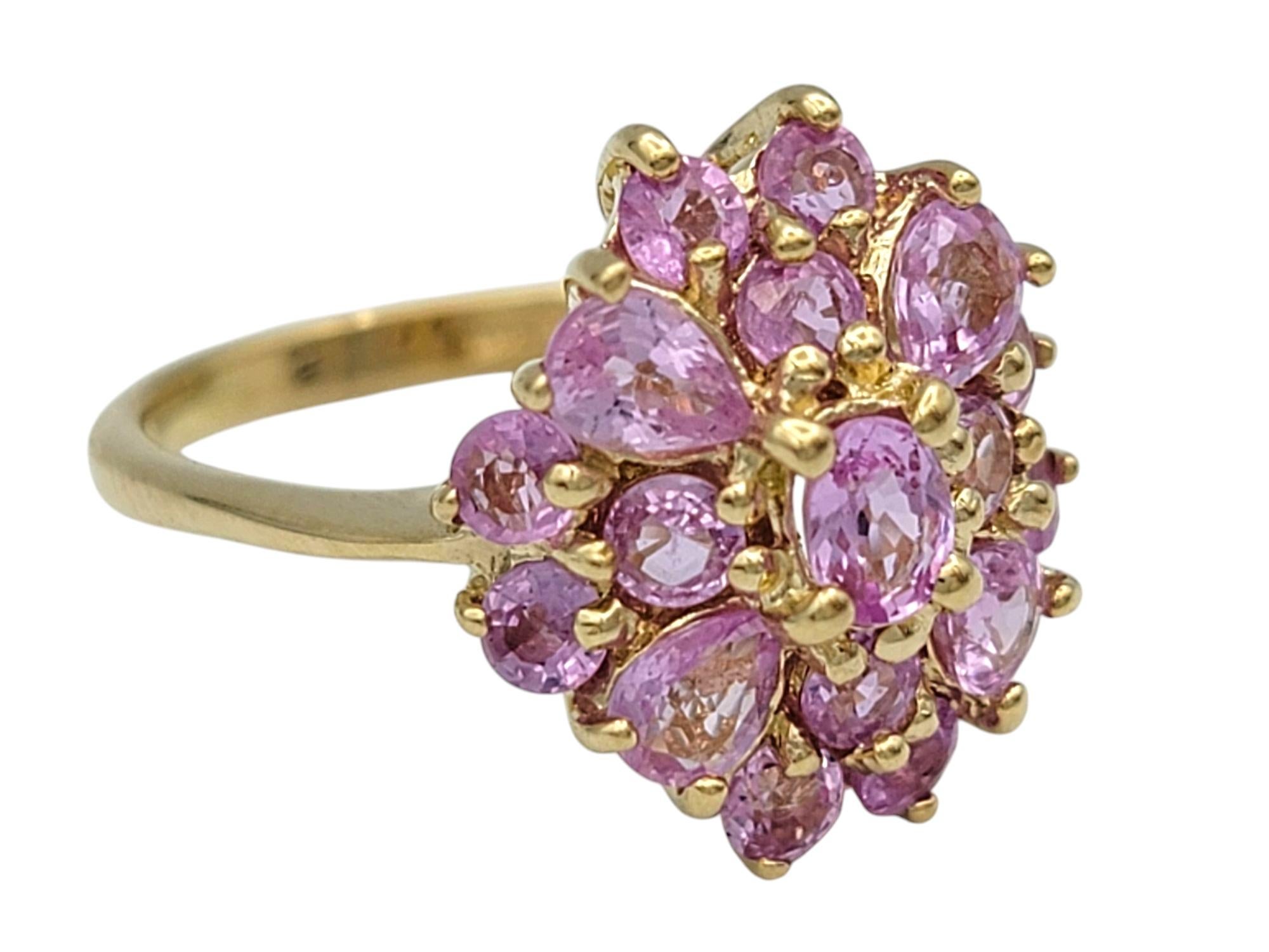 Taille de l'anneau : 4.75

Ajoutez une touche romantique à votre collection avec cette élégante bague en saphir rose, réalisée en or jaune 14 carats. Avec un mélange vibrant de saphirs ronds, poires et ovales, le design en grappe crée une silhouette