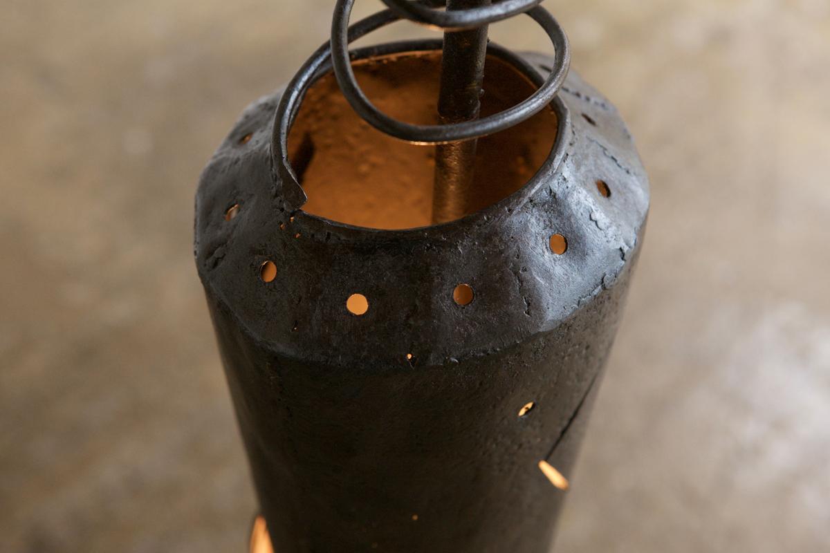 Un lampadaire artistique avec une base éclairante unique en métal qui tient un abat-jour en osier et un orbe en bois. Un produit unique avec une silloutte magnifique qui produit un éclat merveilleux.