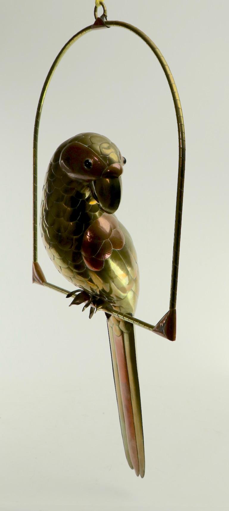 Mixed metal sculpture of a parrot on a swing by recognized master Sergio Bustamante. Very good original condition, having only one slight, insignificant dent on top of head of bird, as shown in images. Classic 1970s metalwork, nice decorative