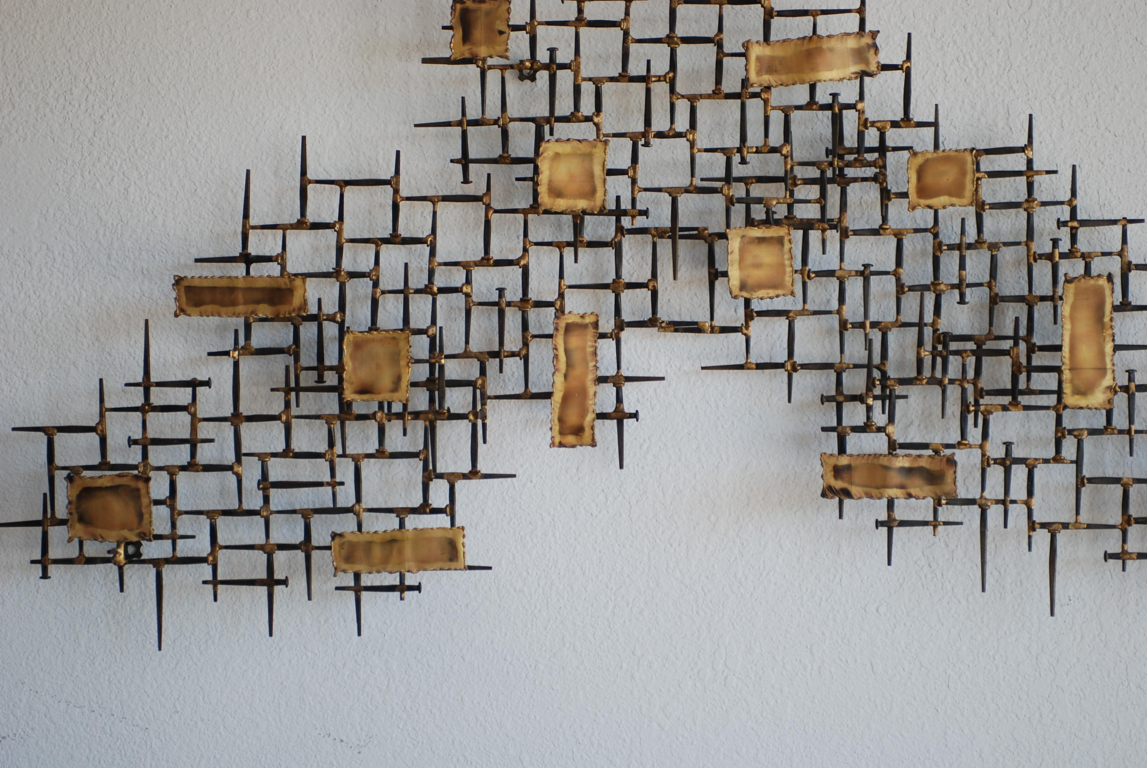 This nail art wall sculpture is signed MF. It is made of iron nails and elevated 'floating' metal panels with beautiful brass coloring.
The mixed metal tones throughout give the work dimension and versatility.