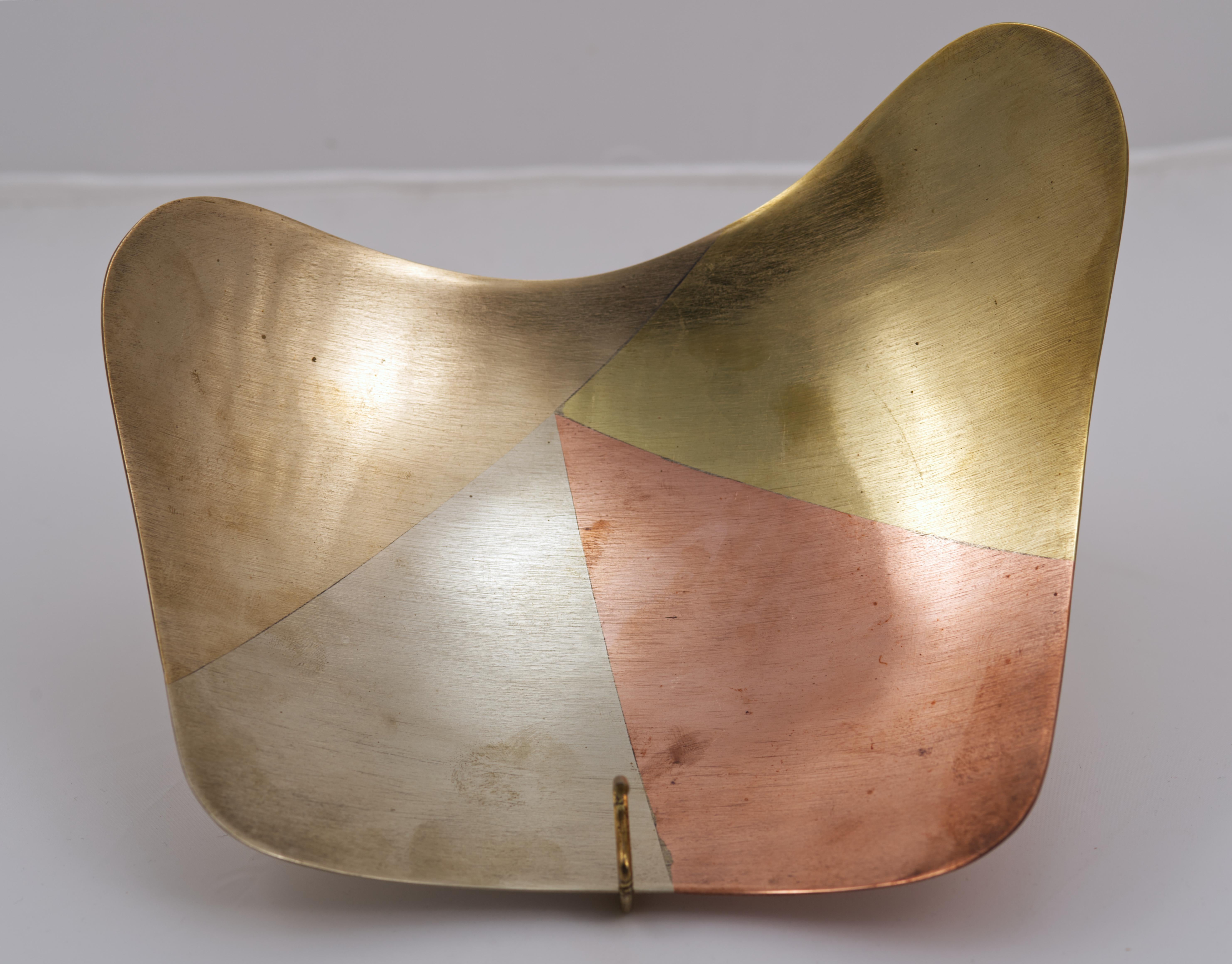  Il vassoio in metallo misto realizzato dagli argentieri messicani di Taxco, Messico, presenta una forma biomorfa asimmetrica e un motivo astratto modernista in ottone, rame, argento e bronzo. I metalli sono fusi senza soluzione di continuità in