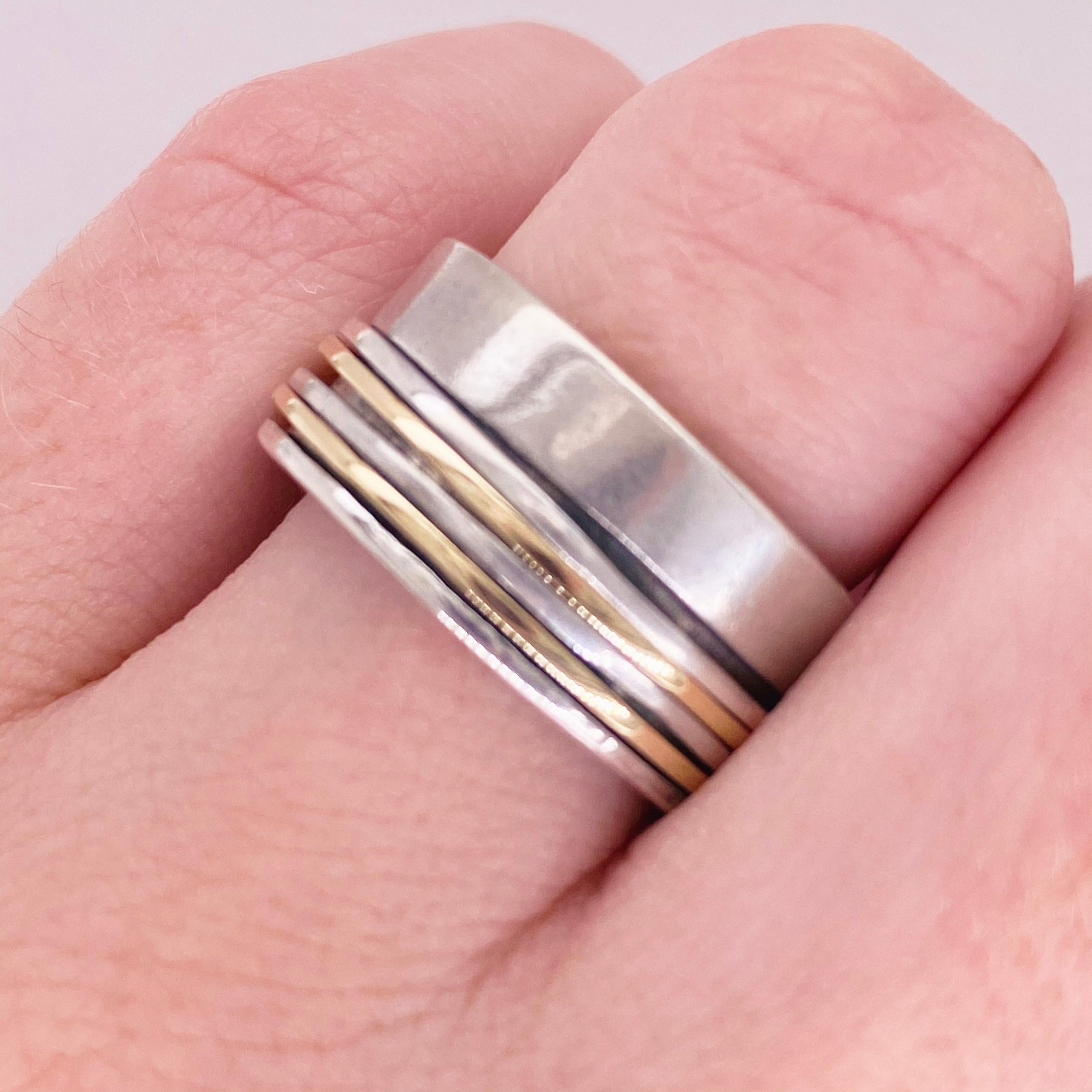 This slick 14Kt gold and sterling silver band ring isn't just a classy fashion statement, it's also great for fidgeters! The solid gold and silver bands spin around their polished silver base. Spinner rings are designed to be fiddled with. They're a
