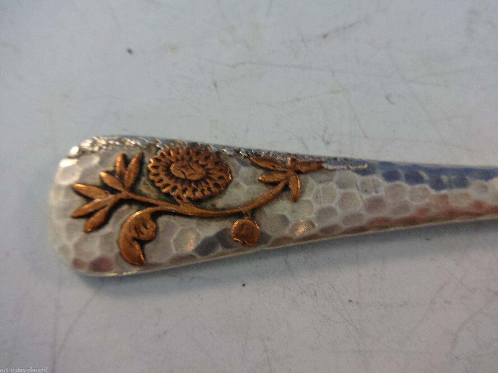 Gorham

Sterling silver 

Gorham mixed metal citrus knife, hand-hammered sterling with applied copper flower and applied silver grains of sand, measures 7 1/4” desirable mark “& other metals” circa 1880s. It is not monogrammed and is in