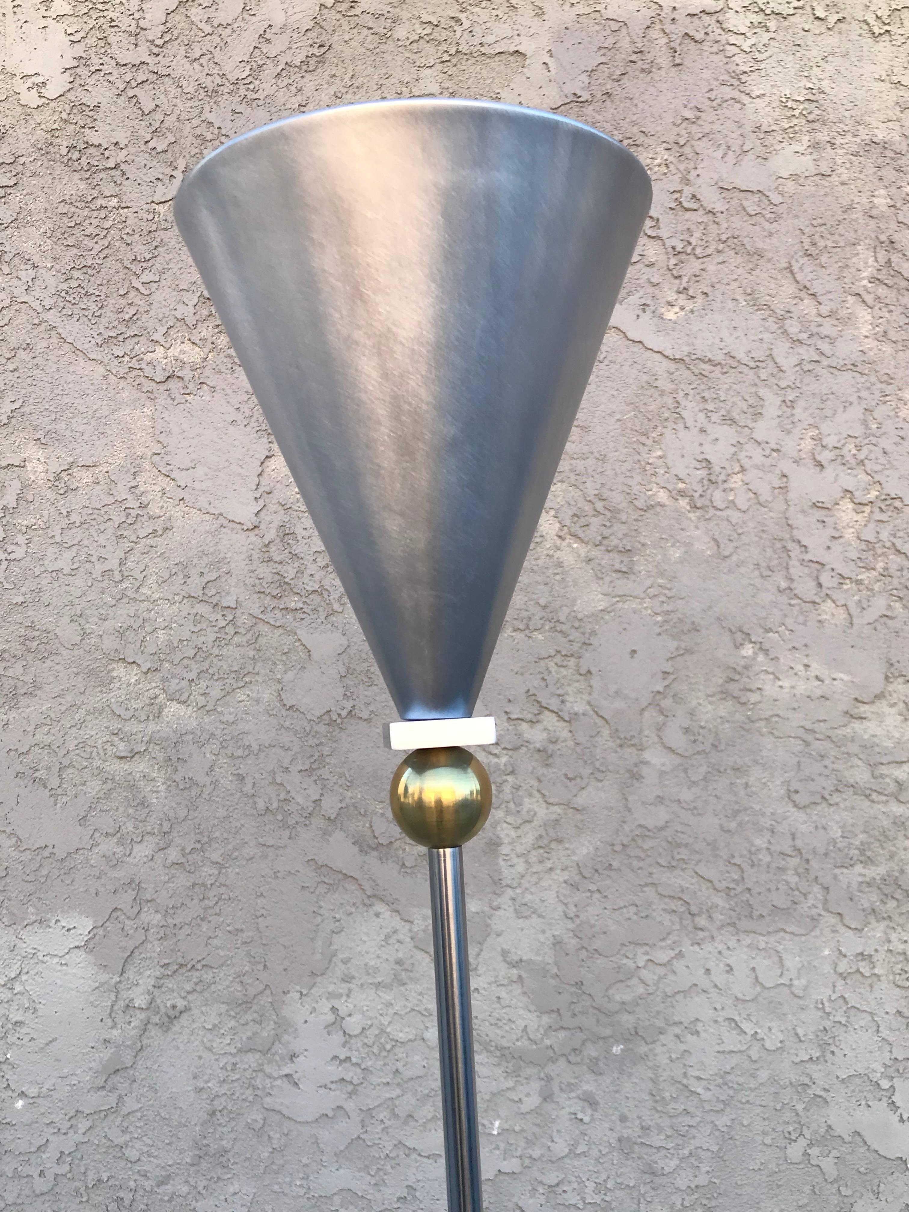 Post-modern floor lamp or torchiere designed by Robert Sonneman for Kovacs. The stem sits on a brass ball floating on a chrome base on both the top and bottom. Aluminium shade and brushed steel base and stem.