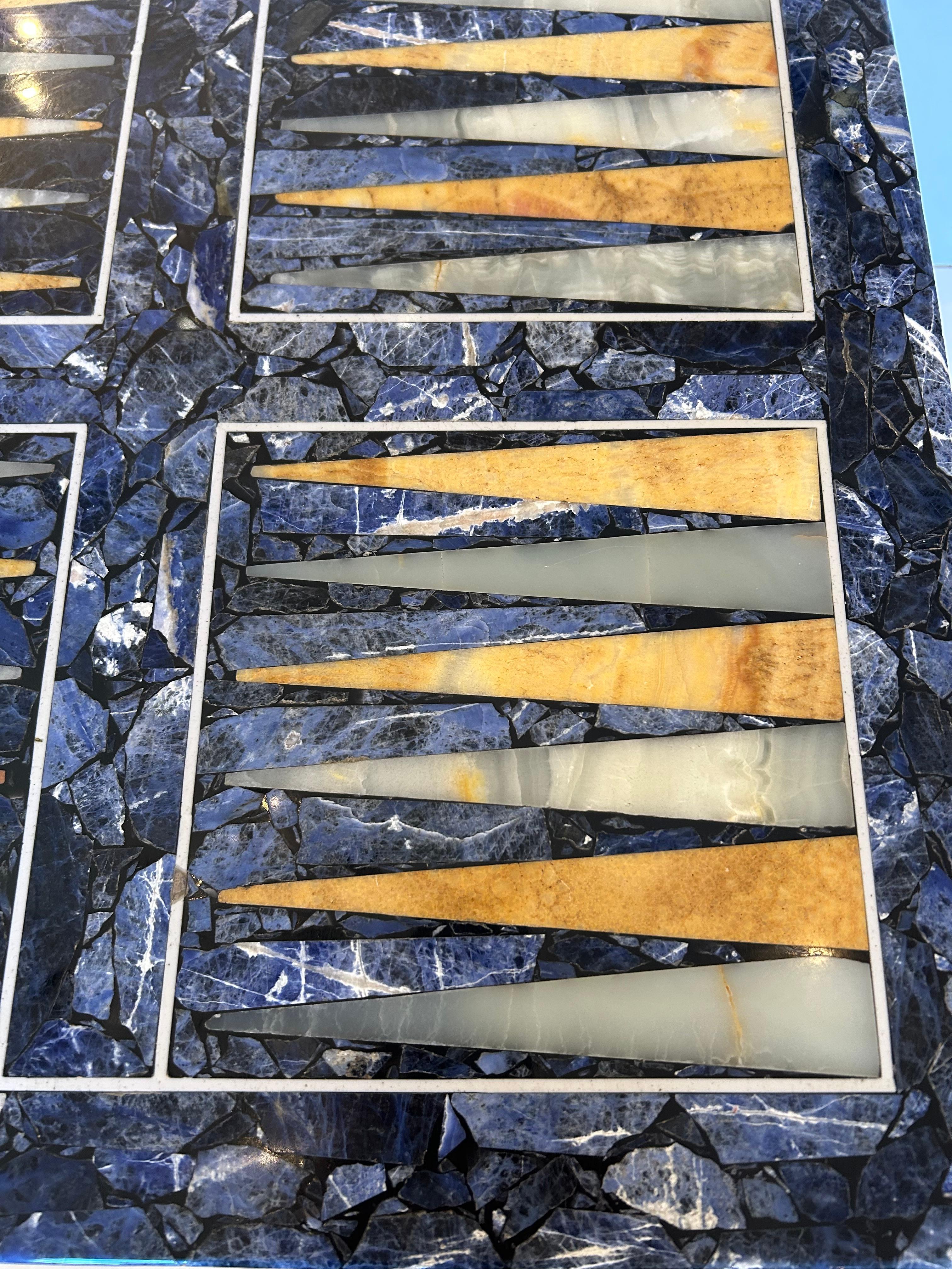 Glamurosa mesa de juego de backgammon con incrustaciones mixtas de piedra, perfecta también como mesa auxiliar, que tiene una base de estilo de mediados de siglo de cromo y latón.  La parte superior probablemente se añadió más tarde.  Creemos que al