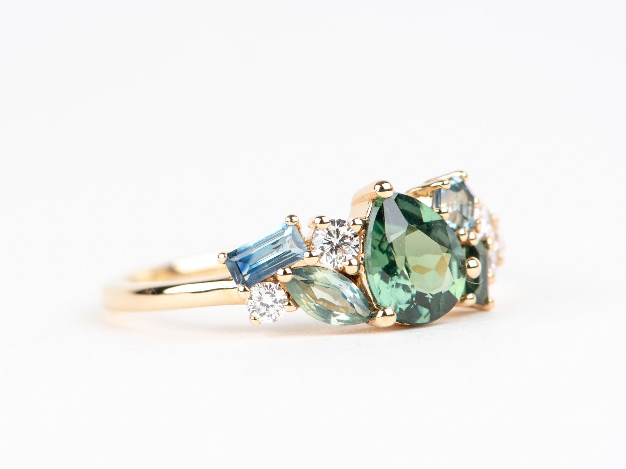 ♥ Gemischter Teal Saphir und Diamant Cluster Ring 14K Gold R6768

♥ Ein einzigartiger Ring mit einem birnenförmigen tealfarbenen Saphir in der Mitte, flankiert von weiteren Saphiren und Labordiamanten an den Seiten
♥ Maße: Dieser Artikel misst 7,3