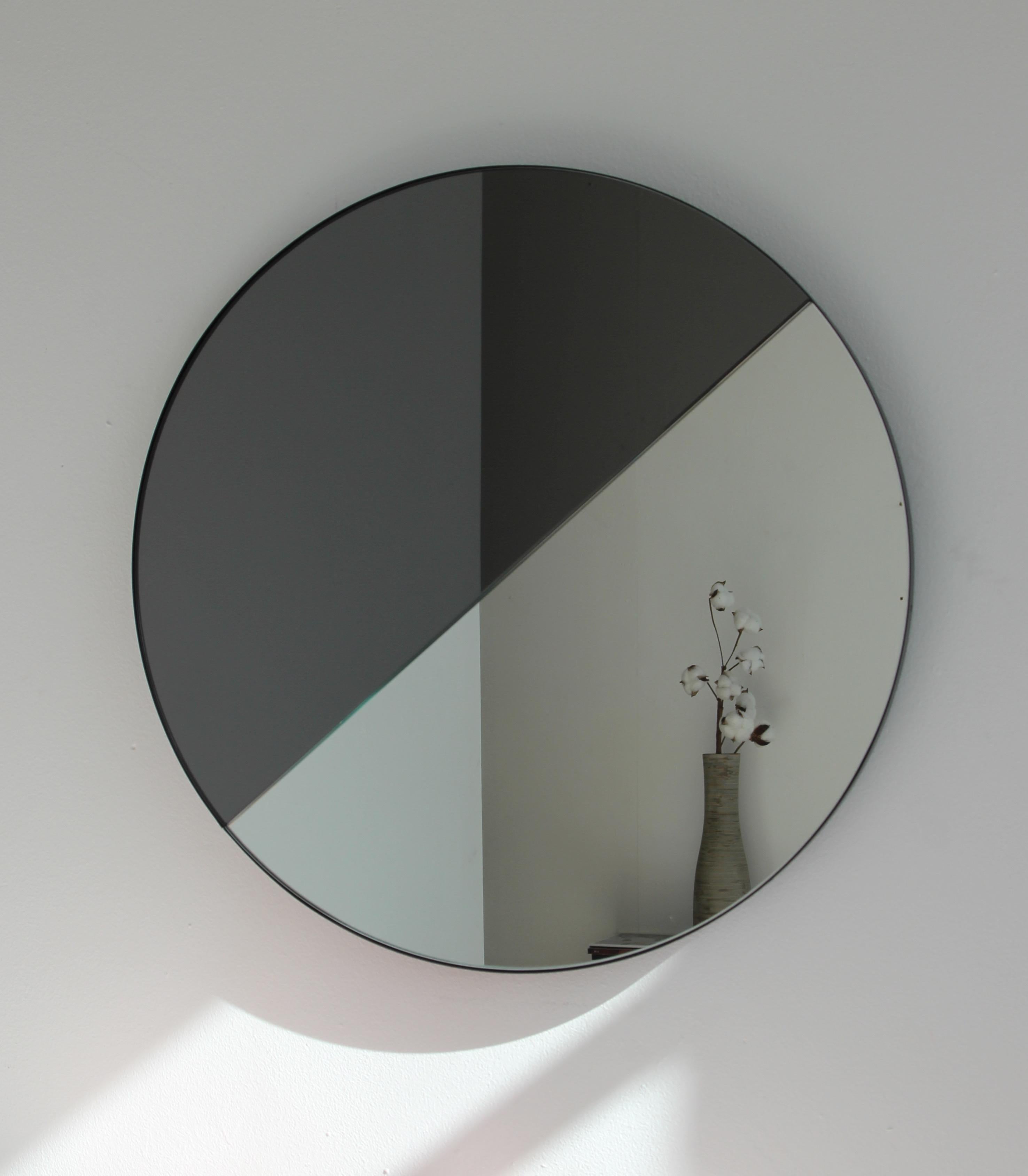 Miroir rond contemporain teinté mixte (noir et argent) avec un cadre noir élégant. Conçu et fabriqué à la main à Londres, au Royaume-Uni.

Tous les miroirs sont équipés d'un ingénieux système de tasseaux à la française (lattes fendues) qui leur