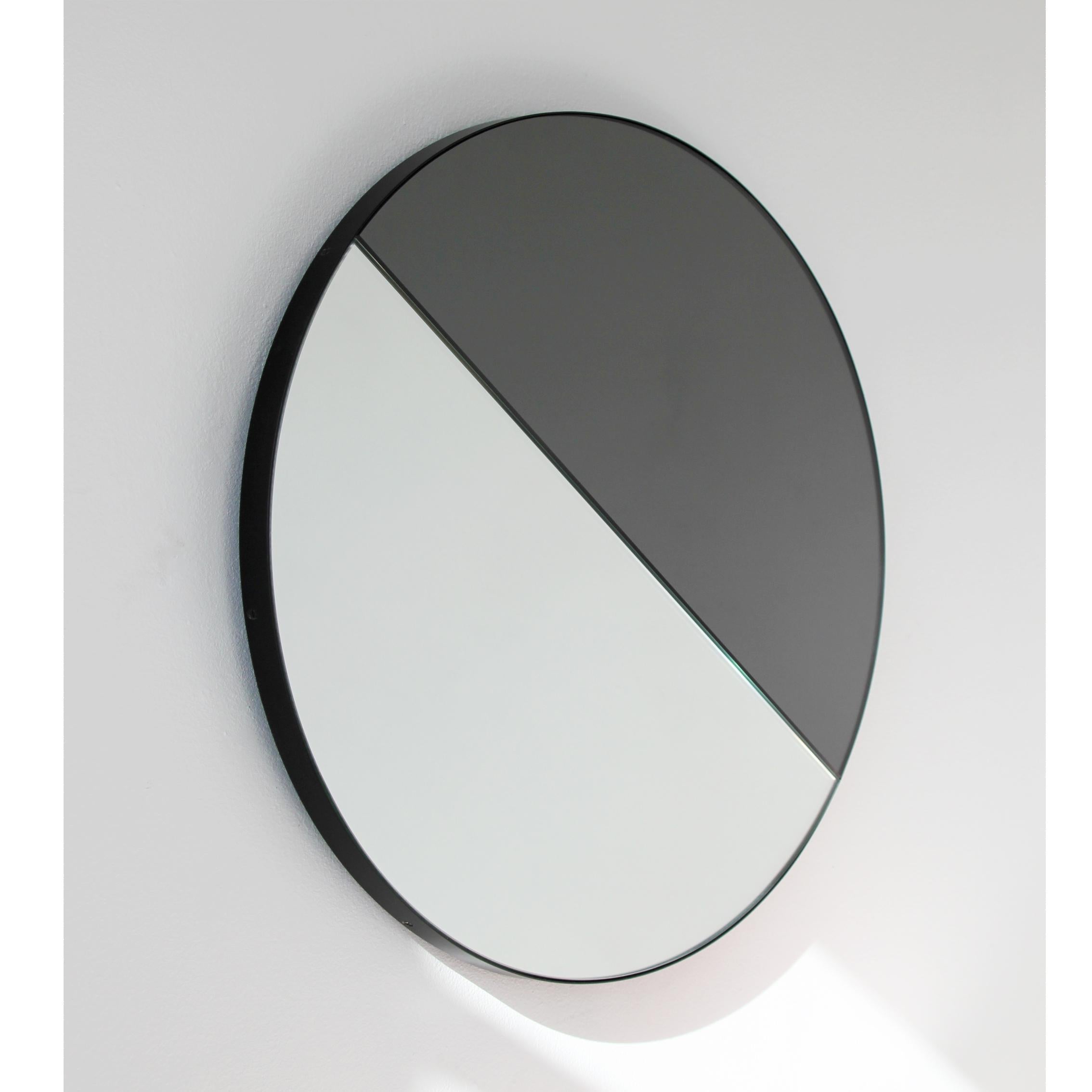 Miroir rond contemporain teinté mixte (noir et argent) avec un cadre noir élégant. Conçu et fabriqué à la main à Londres, au Royaume-Uni.

Tous les miroirs sont équipés d'un ingénieux système de tasseaux à la française (lattes fendues) qui leur