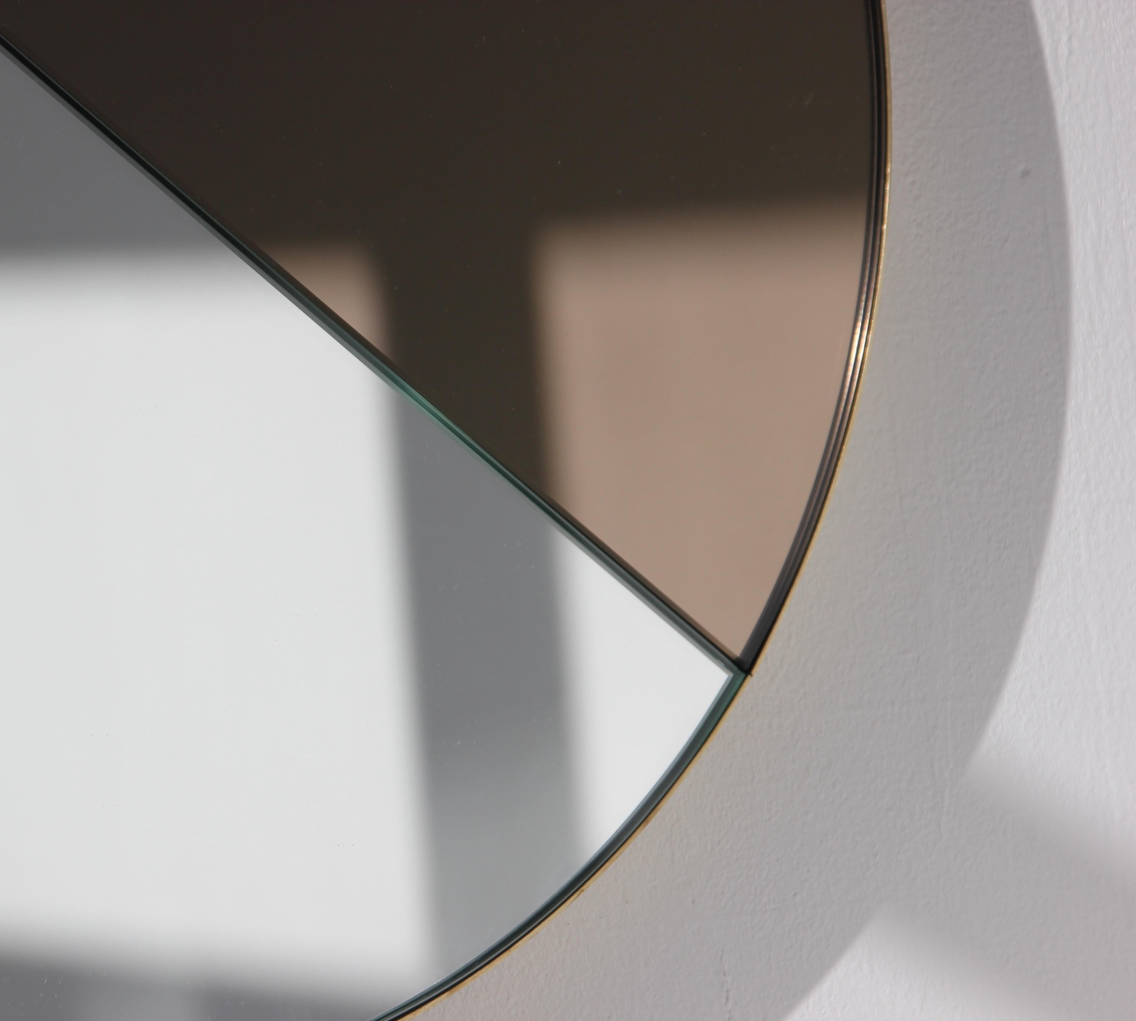 Miroir Orbis Dualis™ contemporain mixte teinté de bronze et d'argent avec un élégant cadre massif en laiton brossé.  Conçu et fabriqué à la main à Londres, au Royaume-Uni.

Tous les miroirs sont équipés d'un ingénieux système de tasseaux à la