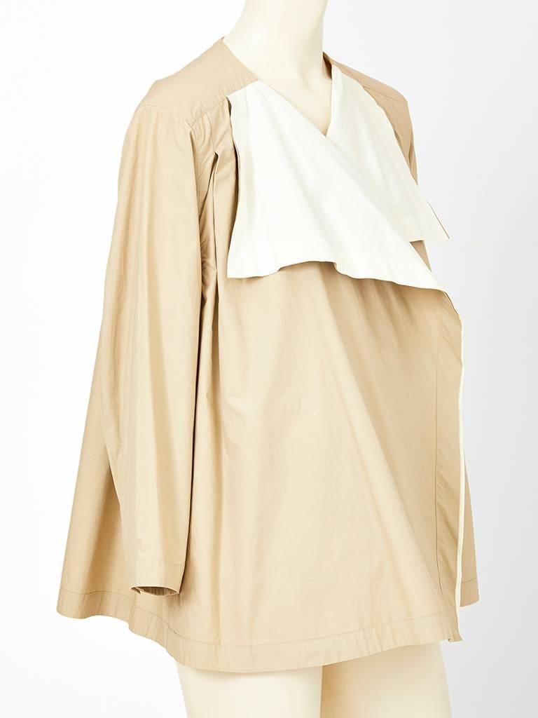 Issey Miyake, tan and white double face cotton, square shaped jacket having no collar or closures. Jacket can be worn open exposing the white interior having soft lapels. Back has an inverted pleat detail.