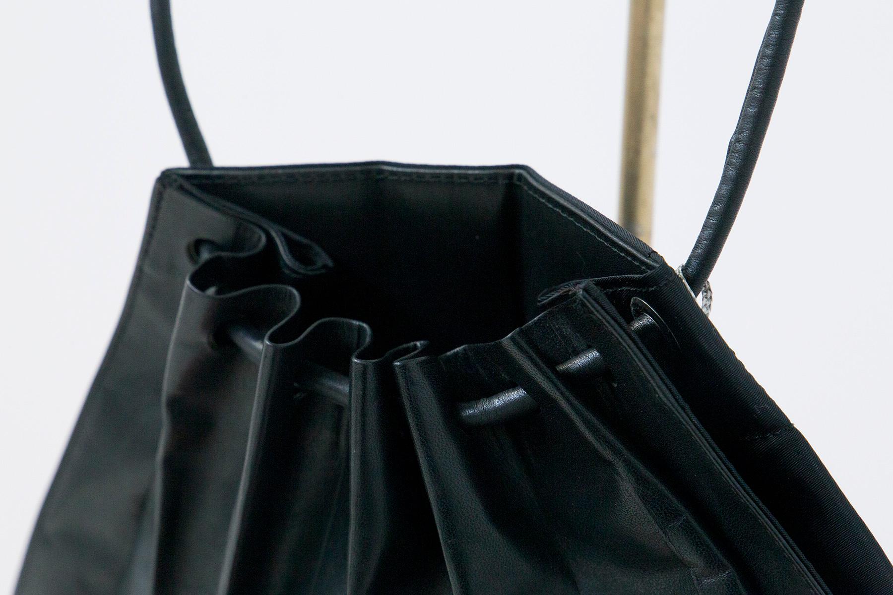 Beautiful black leather bag with characteristic pleating created by Issey Miyake (1938 - 2022) in the 1990s.
The bag is suitable for both daytime and evening events, as leather lends elegance to any time of day. This bag has 8a trapezoidal central