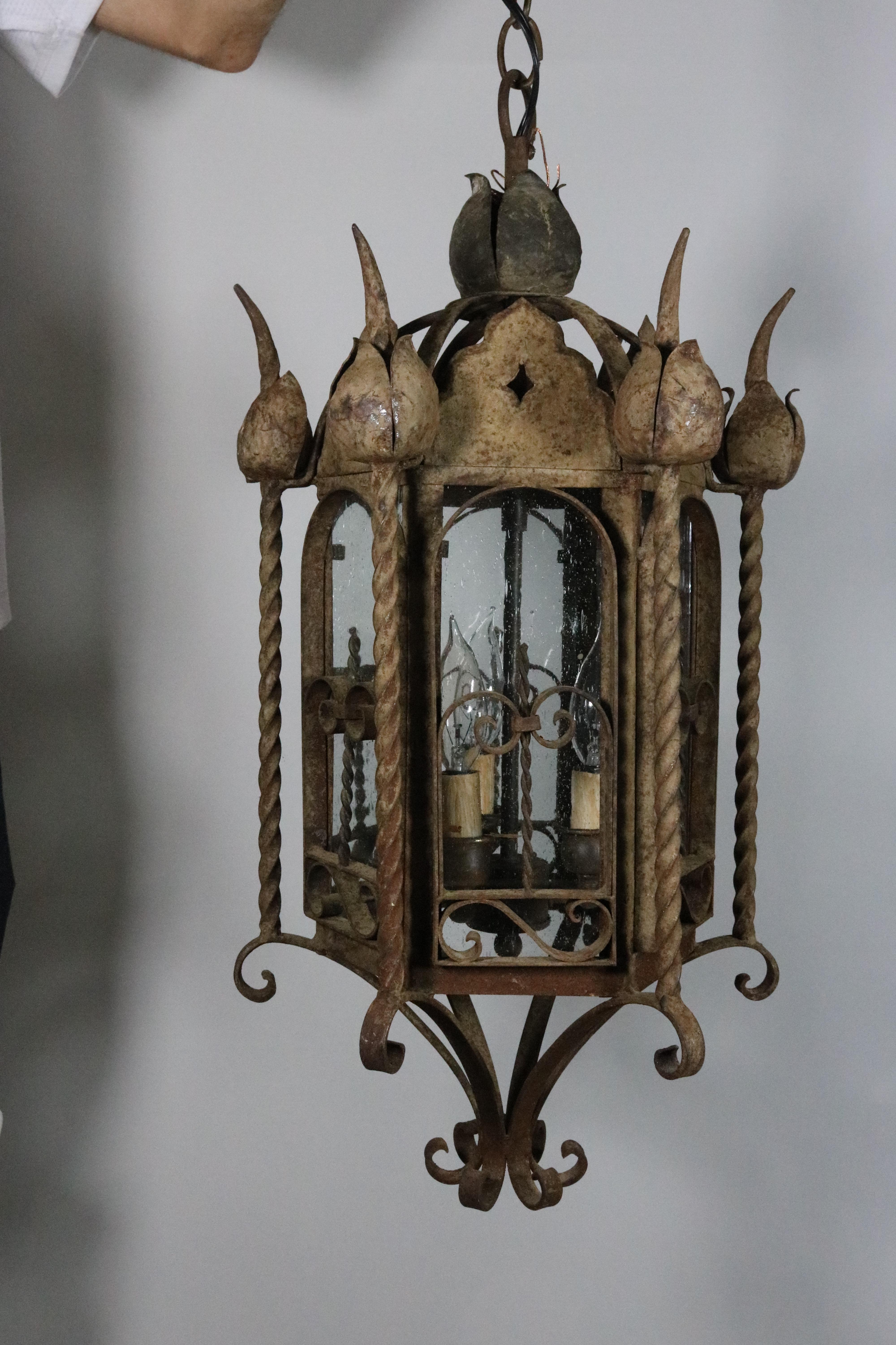 Mizner Outdoor Pair Seed Glass Iron Lanterns-Rusticated Finish-circa 1900s In Good Condition For Sale In West Palm Beach, FL