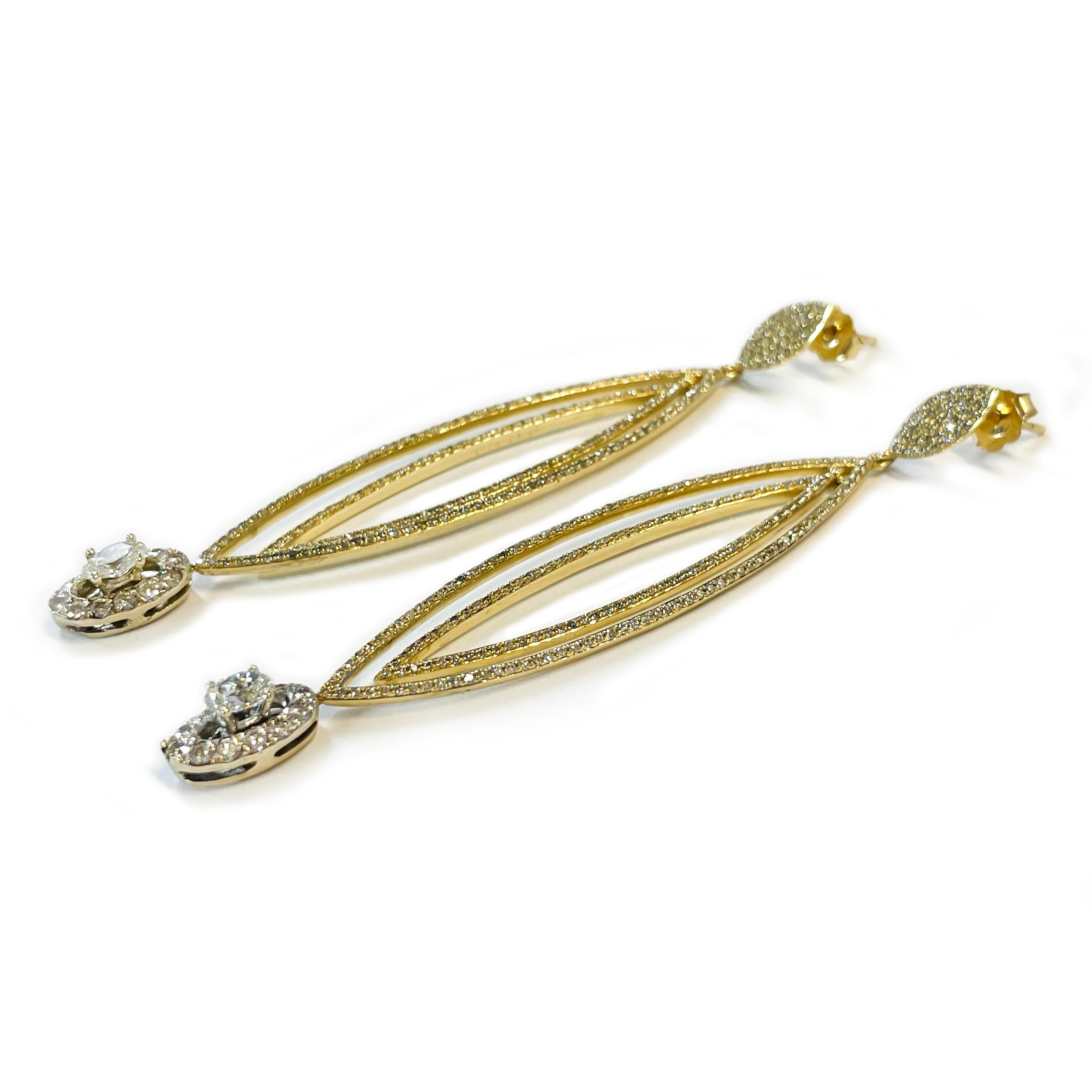 14 Karat Yellow Gold Ellipse Diamond Earrings. These extra sparkly earrings feature pave and bead-set diamonds on two elongated ellipse-shaped pointy hoops and a larger oval diamond with round diamond halo at the bottom. The larger two primary oval