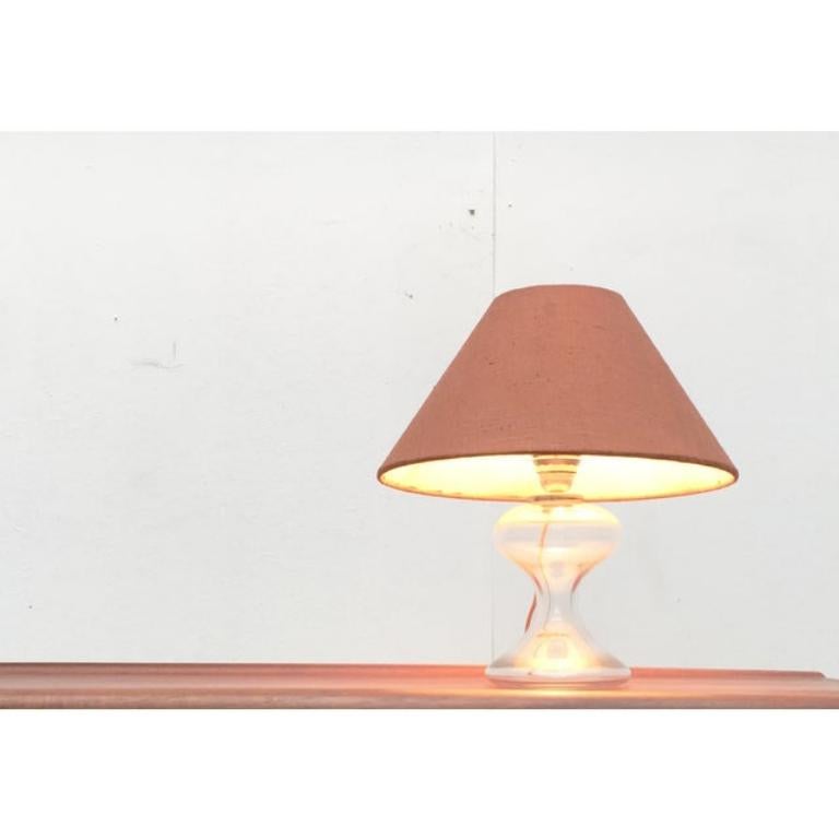 Un primer boceto del famoso diseñador de iluminación Ingo Maurer a finales de los años 60
Un diseño elegante y clásico
El pie es de cristal transparente
La pantalla tiene una forma sencilla y clásica
Se obtiene del exterior con un tejido rojo de