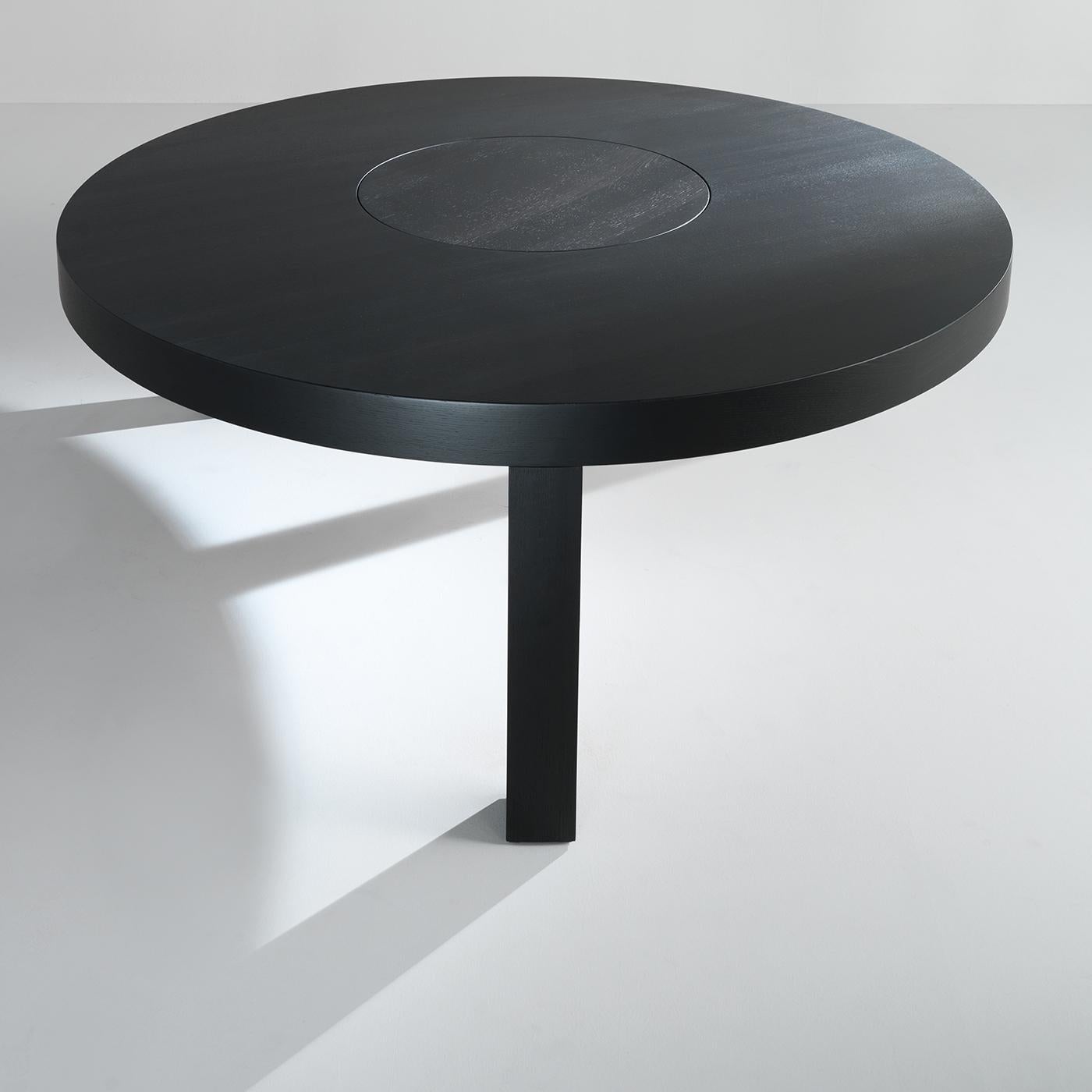 This round wood table has an elegant black finish. The table top is supported entirely by three wood legs, and the top features a lazy Susan in the middle for a combination of practicality and elegance. This beautiful piece will be a perfect