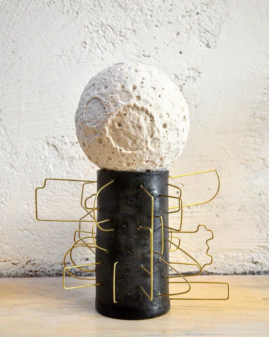 This moon sculpture by Mikel Durlam and Monty J is a collaborative piece from their 2017 two-person show at Greenpoint Hill.

The slip-cast porcelain moon is made from an original hand-sculpted by the artists and supported by a black ceramic