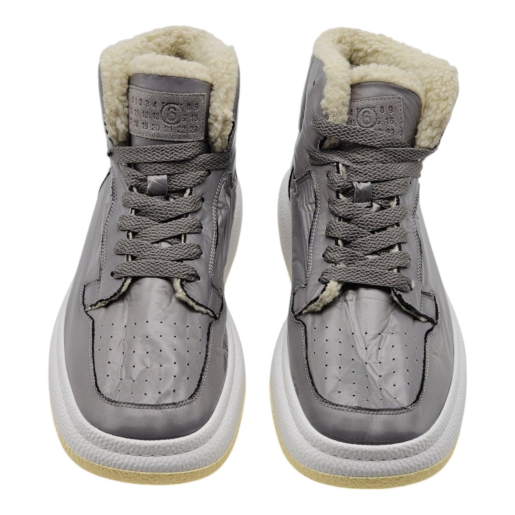 MM6 Maison Margiela Gray High Top Basketball Sneakers

High-top padded taffeta sneakers in gray.

Perforated detailing at square toe, Lace-up closure, Suede logo patch at tongue, Signature white stitching at heel counter, Faux-shearling lining,
