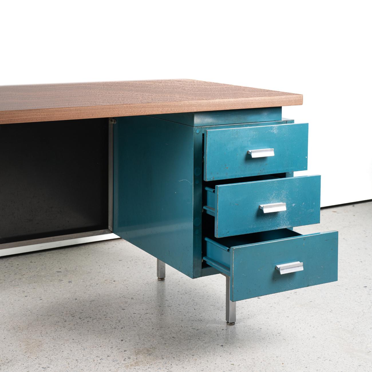 The MMG desk, which was produced for a short period of only 5 years, was designed with 22 parts in a modular form that can be combined according to the user's choice. 
It is often written as a design by Goerge Nelson Associates, but if you trace the