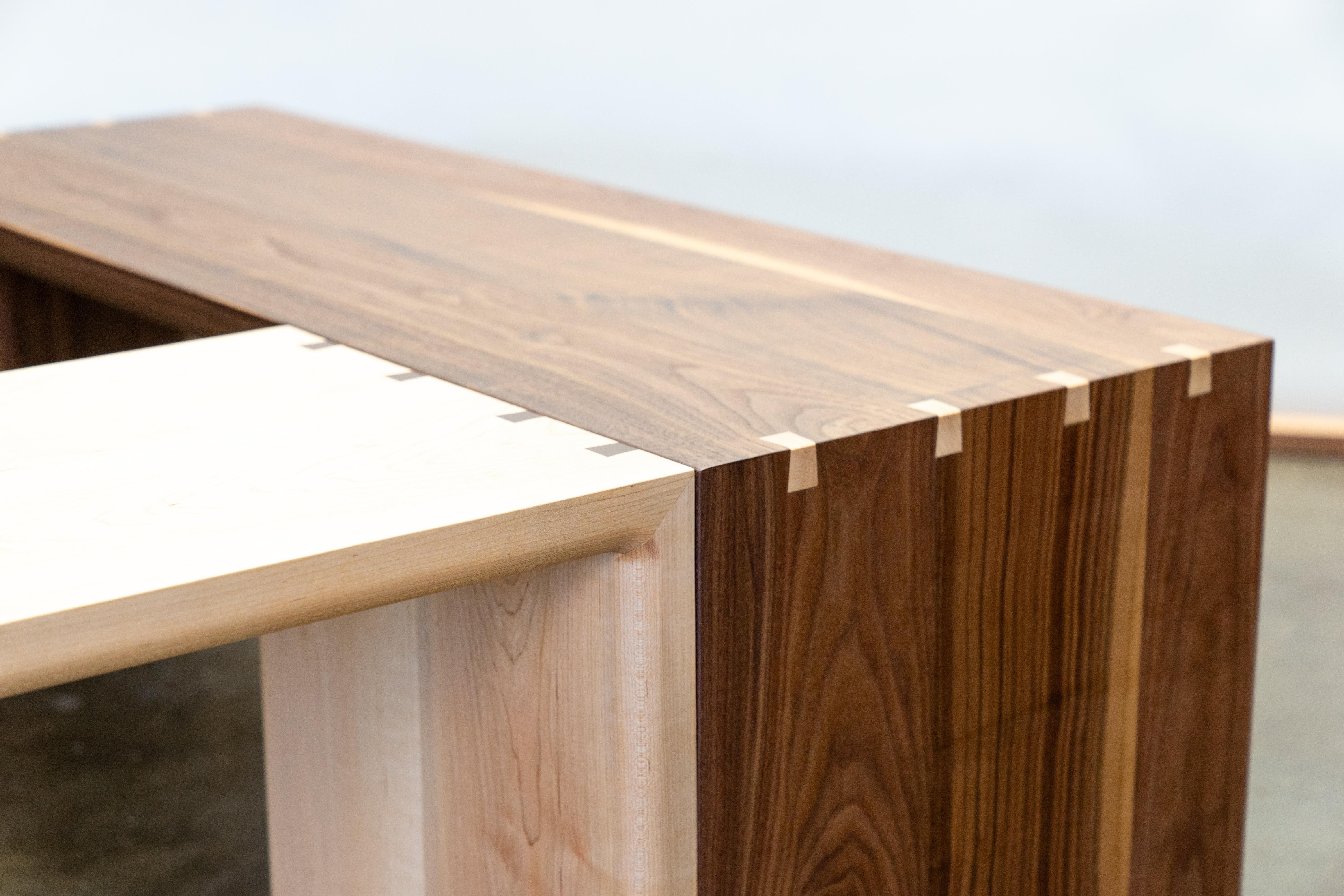 The Mo Bench is a simple, hardwood form that highlights the natural flow of grain as it cascades cleanly over each mitered edge. Dovetail splines strengthen and accent the joints, revealing the craftsmanship behind an otherwise quiet design. Built