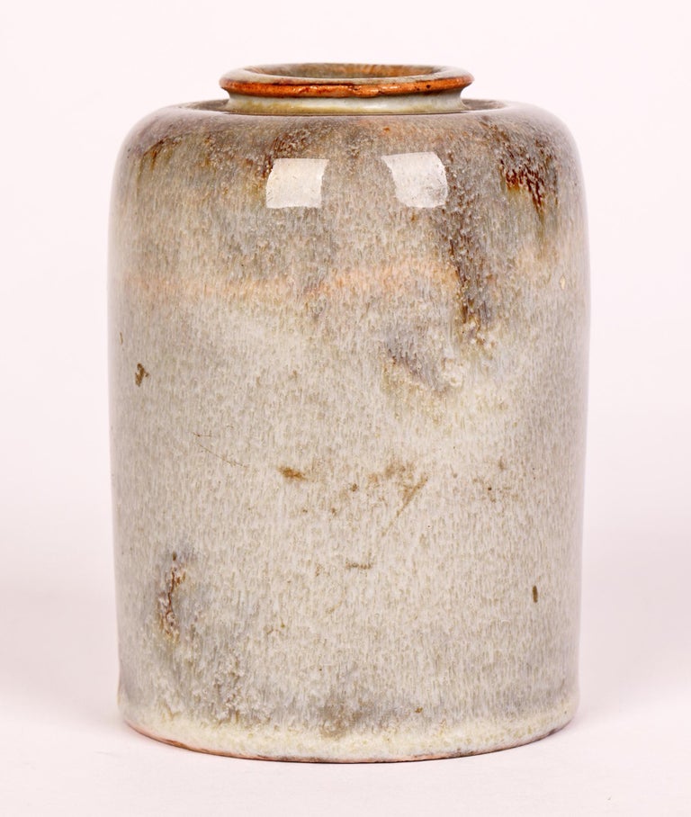 A stylish Dutch Art Deco studio pottery vase decorated in grey hares fur glazes dating from around 1930. The stoneware hand-crafted vase is contemporary for its period and stands on a flat round base and is of tall cylindrical shape with a round and