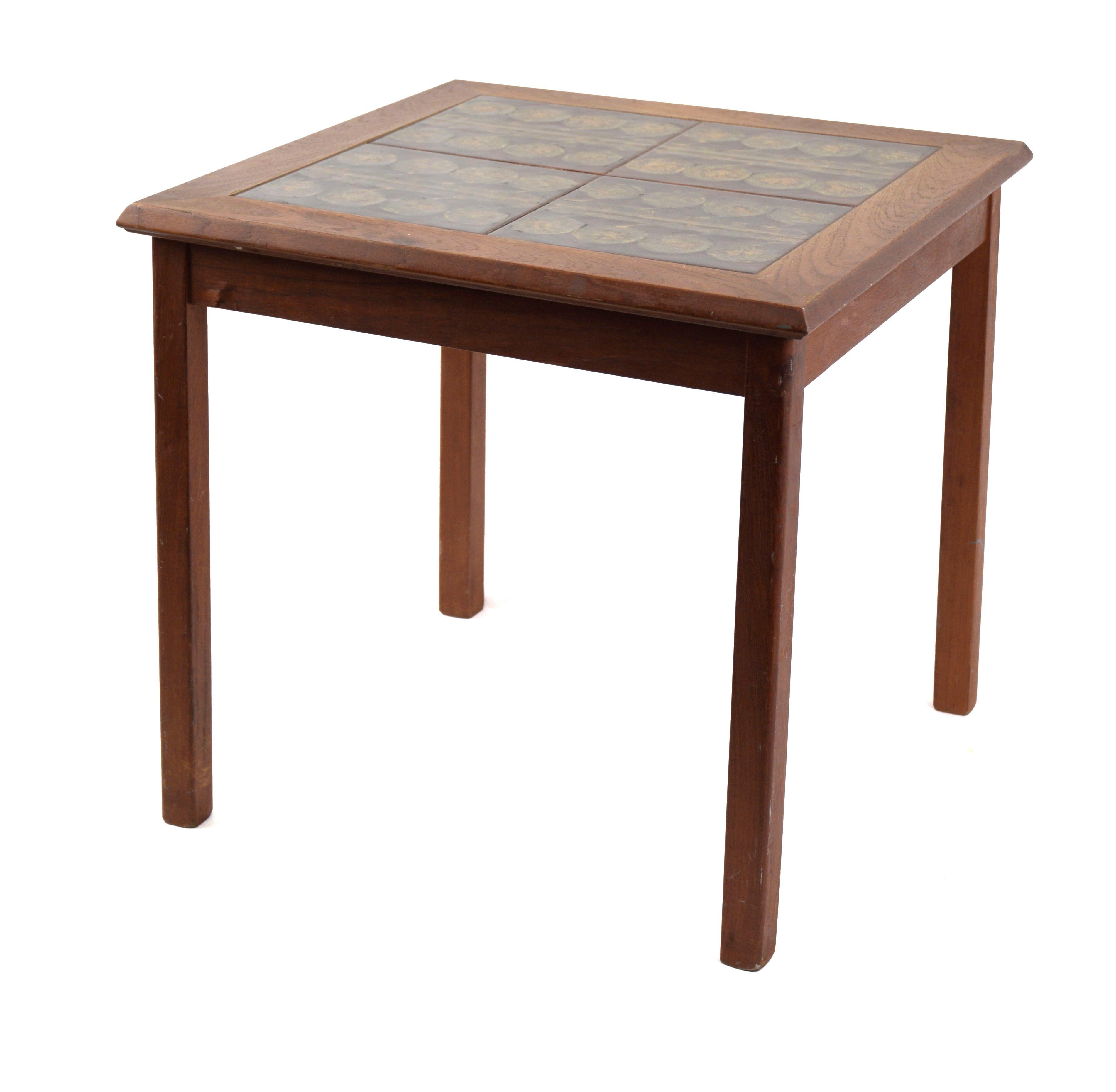 Mobelfabrikken Toften Teak End Table with Tile Top

Solid wood table with four tiles inlaid in the top. All of the tiles have the same pattern, eight circles divided by a line. The tiles have a warm, dark red and yellow coloration. Stamp on the