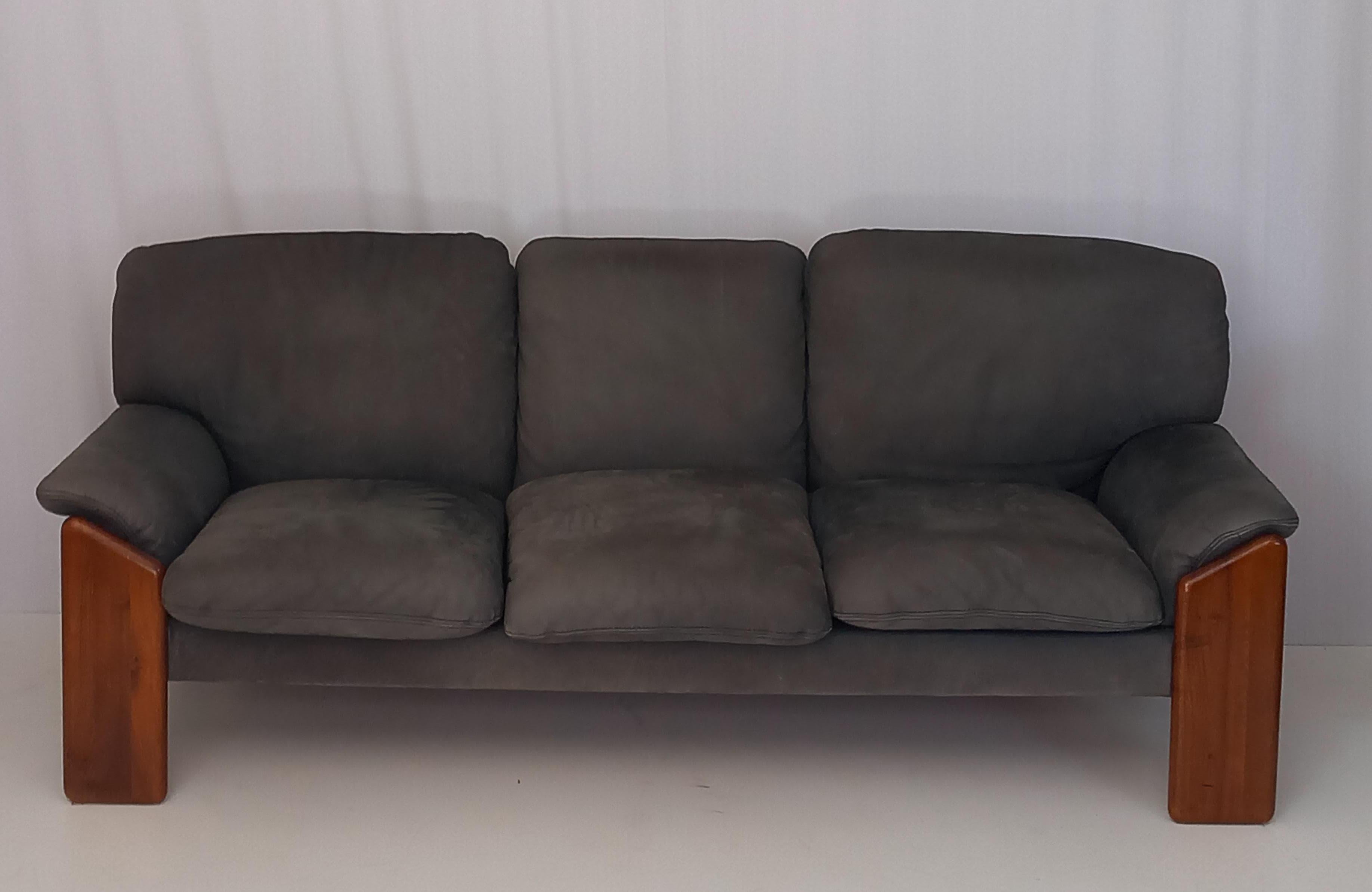 This vintage mid-century sofa, produced in the 1970s by the renowned Italian furniture firm Mobil Girgi, is a striking example of timeless design and sophisticated craftsmanship. Upholstered in grey leather, the sofa features a sturdy walnut