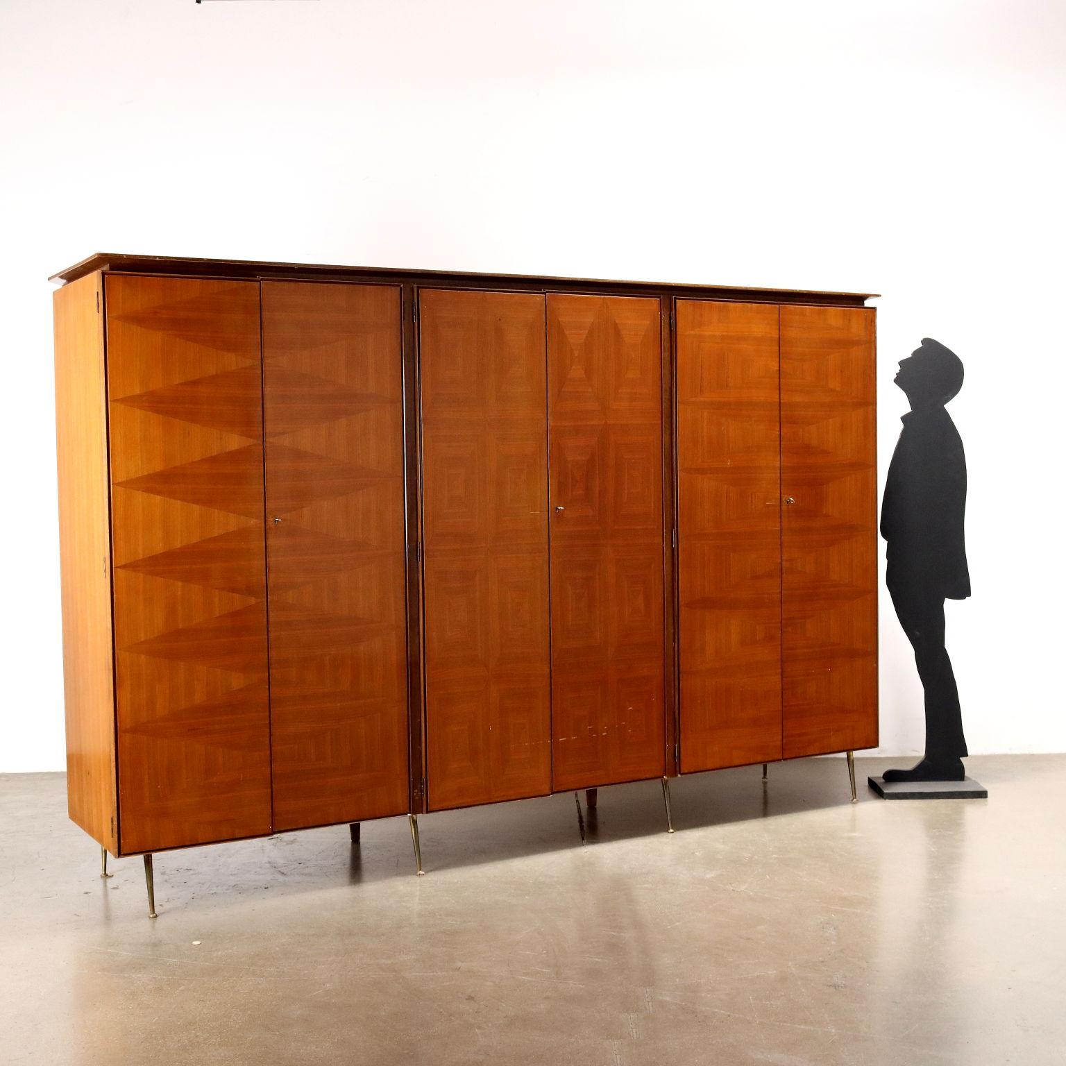 Hinged door cabinet made of walnut veneered wood and brass legs. It shows some marks on the polish.
