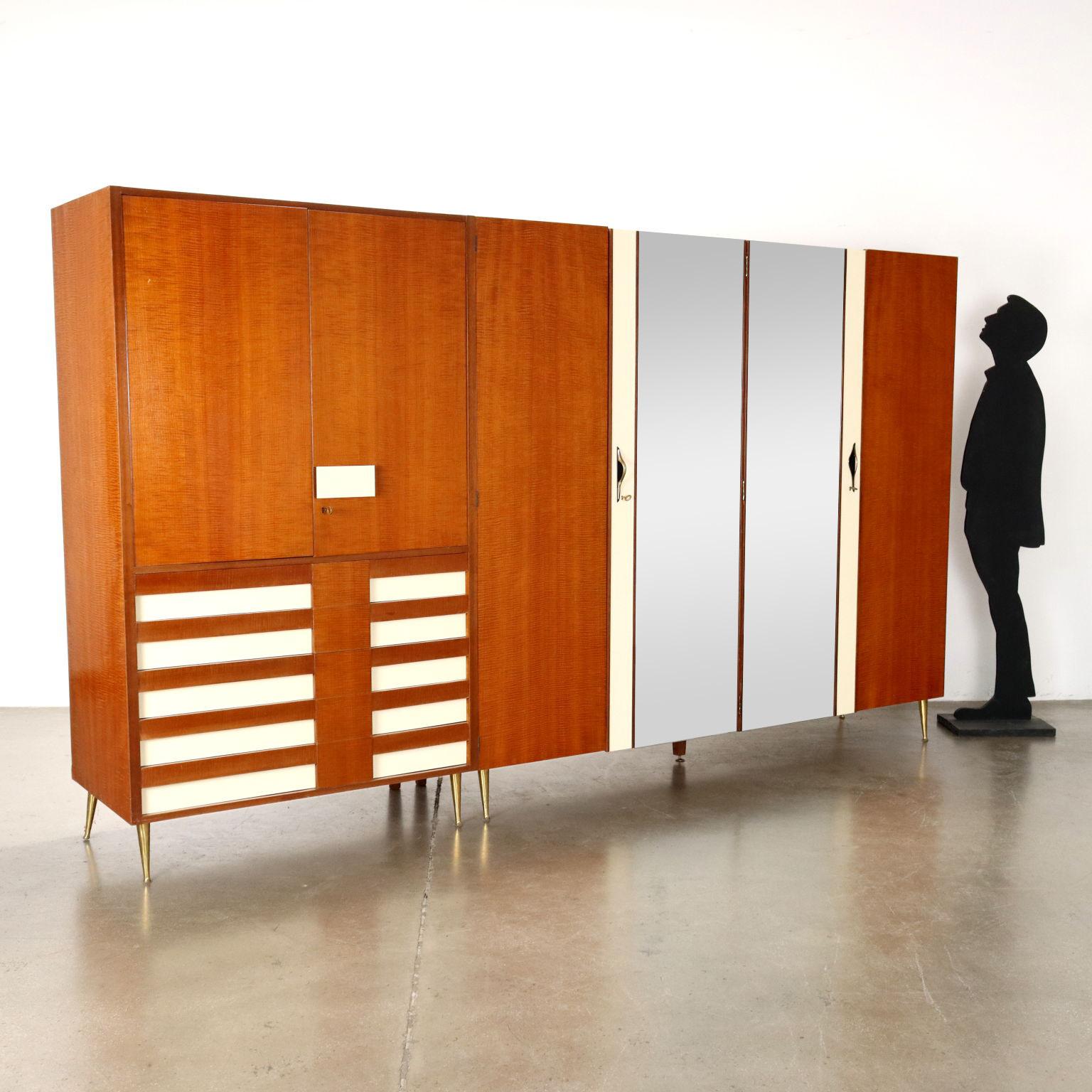 Armoire à portes battantes, bois plaqué acajou, inserts Formica, verre miroir, pieds en laiton. 