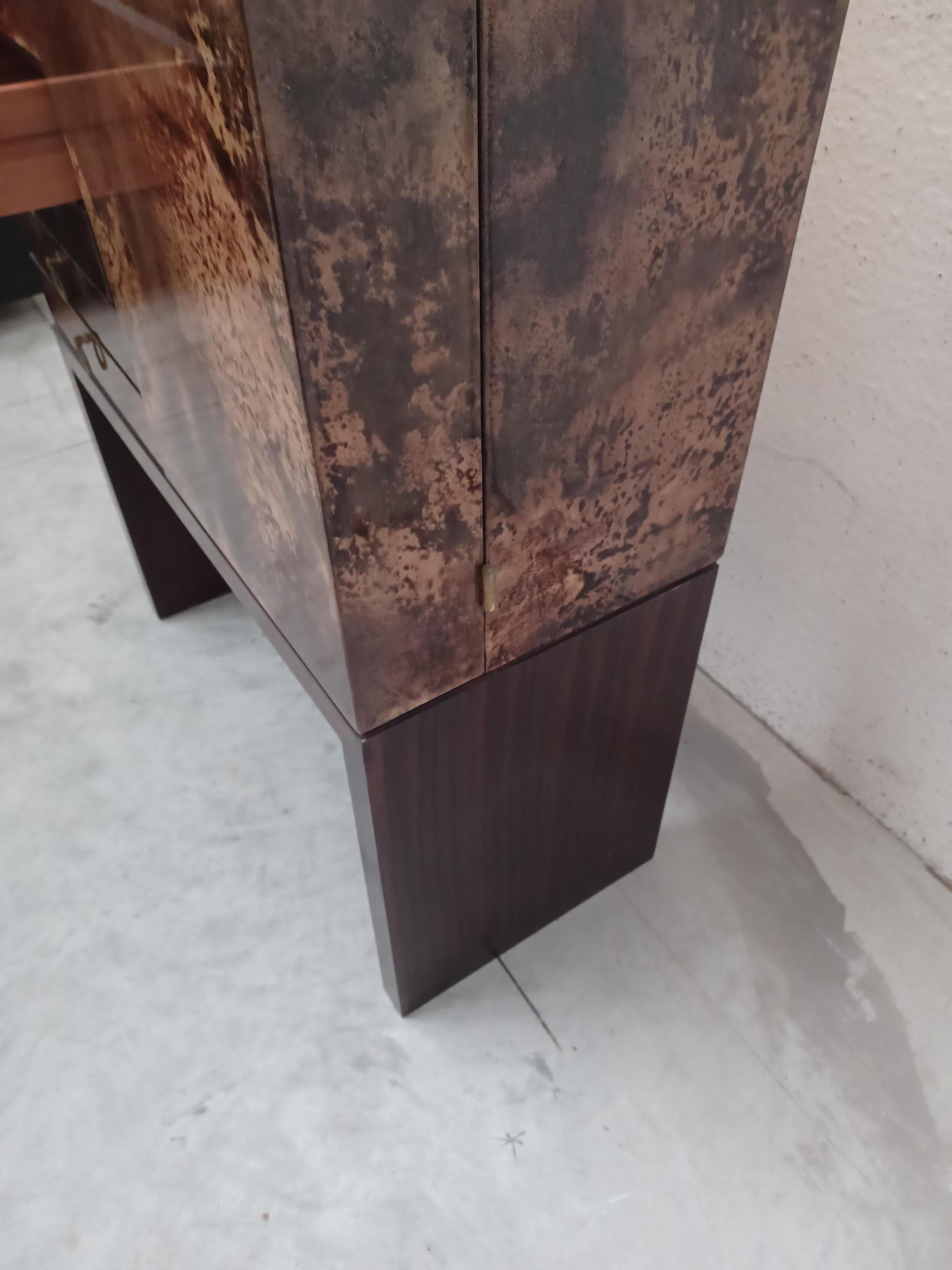 Mobile bar di Aldo Tura . Interni specchiati. Esecuzione eccellente e raffinata in pergamena su tutta la parte esterna . Chiavi originali .Per chi vuole inserire nella propria abitazione non il solito bar.  Ottimo lo stato di conservazione. 