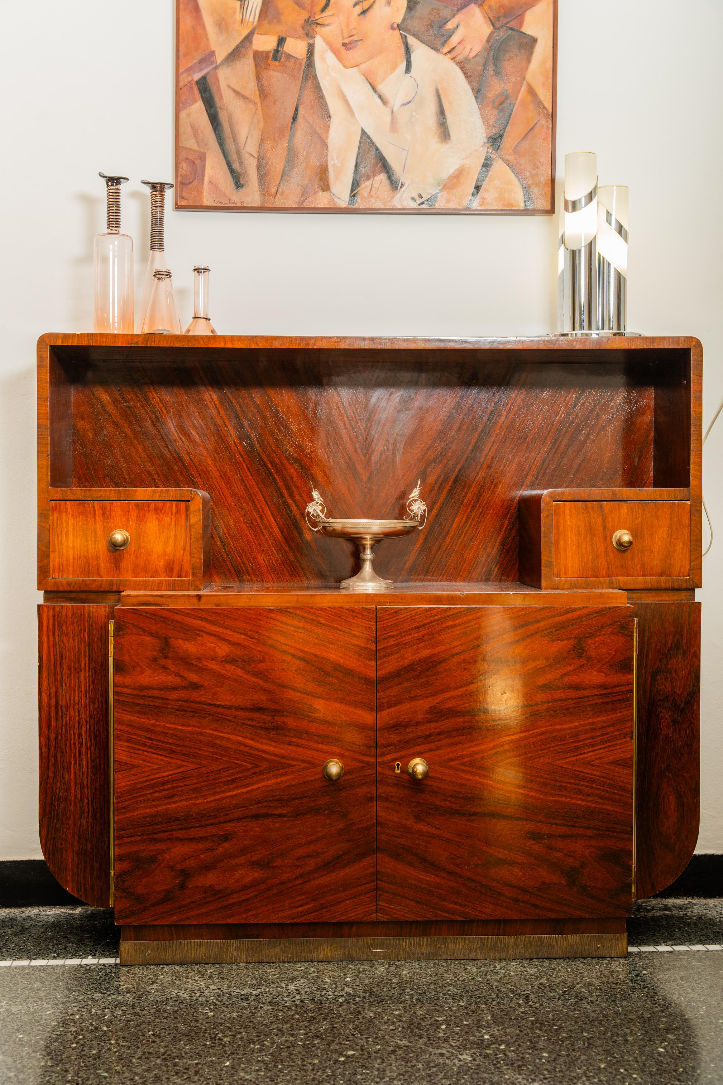 Important meuble de bar déco en bois foncé avec deux portes et deux tiroirs. Créé par la société italienne Ducrot dans les années 1920, il porte l'étiquette du fabricant dans le tiroir gauche5000
