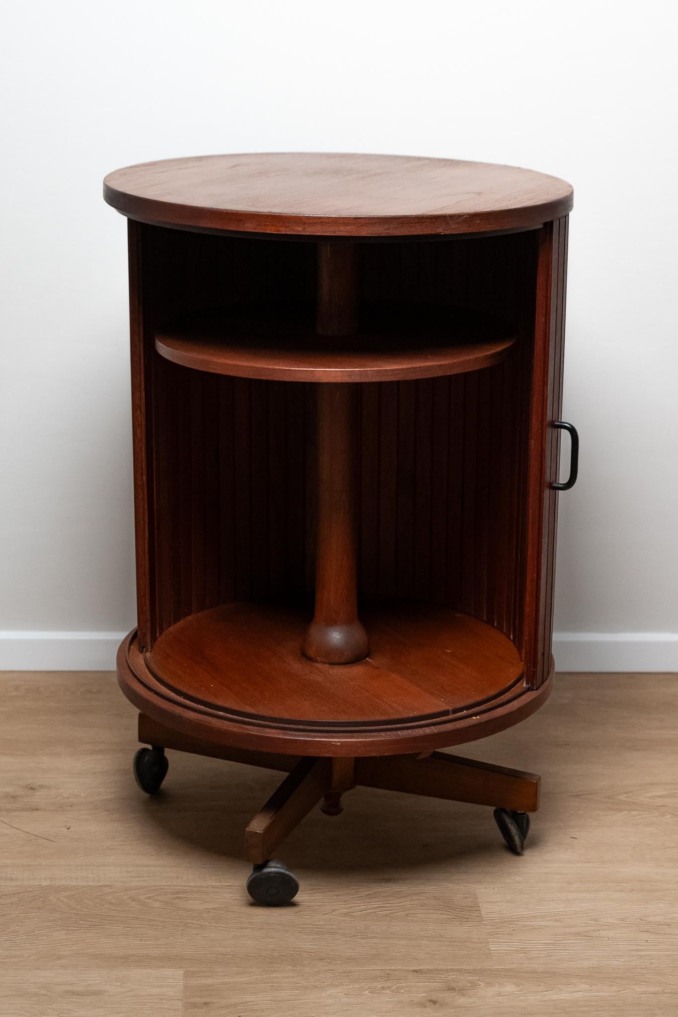 Mobile bar girevole in teak,  Made in Italy, Anni '60. 
Mobile bar girevole in teak con serranda scorrevole e piede a quattro razze con rotelle. 
E' tutto ORIGINALE e mantiene la patina del tempo. 
Può presentare lievi segni di usura dovuti al tempo