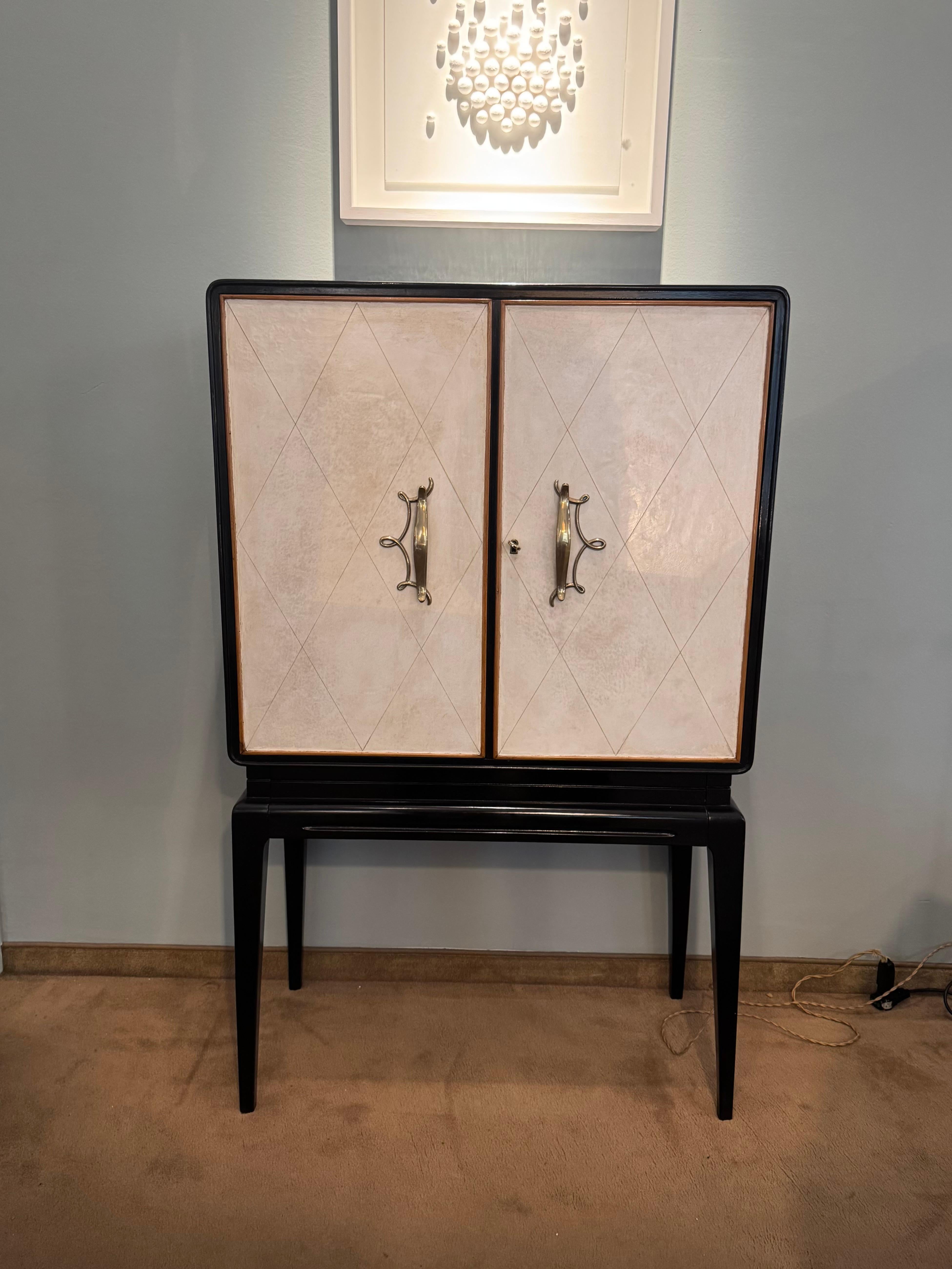 Elegant Art Deco bar cabinet.
Made in France in the 1930s, this unique bar cabinet is made of ebonized wood.
The doors are parchment and the handles are brass.
It also has a handy bottom drawer.
The lines and techniques are typical of French