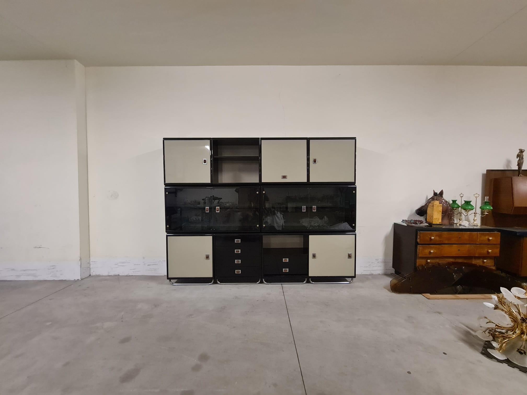 Modular furniture by Guido Faleschini for Mariani.

Large cabinet composed of 9 modules in black and beige lacquered wood with chrome and leather details.

The cabinet consists of three modules with chrome legs that serve as the base, two double